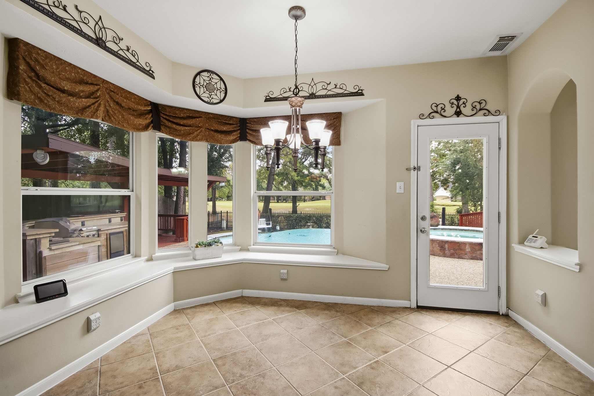 Charming kitchen nook featuring built-in seating, ready for your dining table, with beautiful views overlooking the sparkling pool. The perfect spot to enjoy your morning coffee or casual meals!