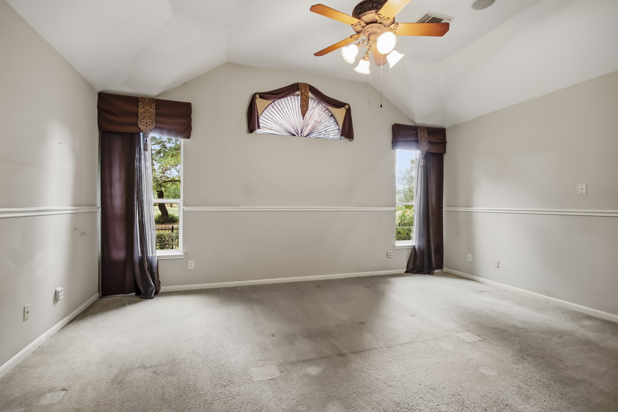 Expansive primary bedroom featuring a ceiling fan, abundant natural light, and breathtaking views of your sparkling pool and lush golf course, creating the perfect private retreat!