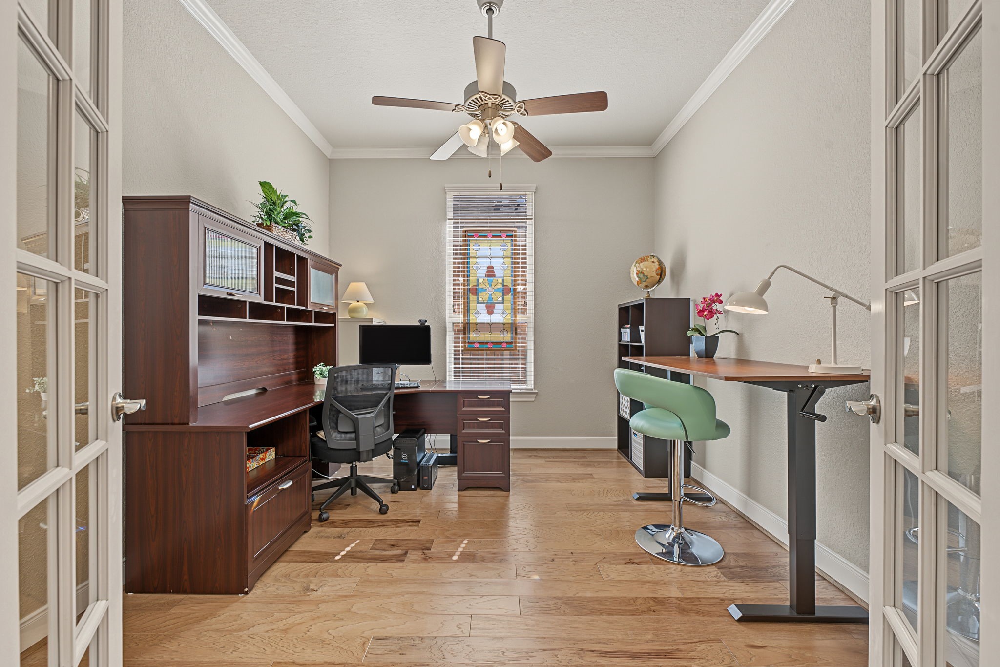 This home office/study is approx 12' x 11' with LVP flooring, crown molding, and double French doors for privacy.