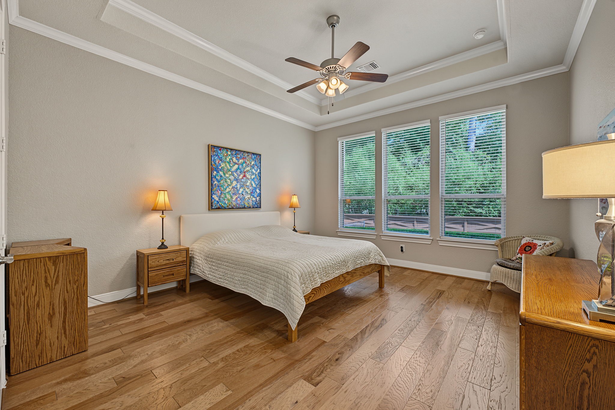 The Primary Bedroom looks out to the tree preserve and backyard. Tray ceilings with double crown molding.