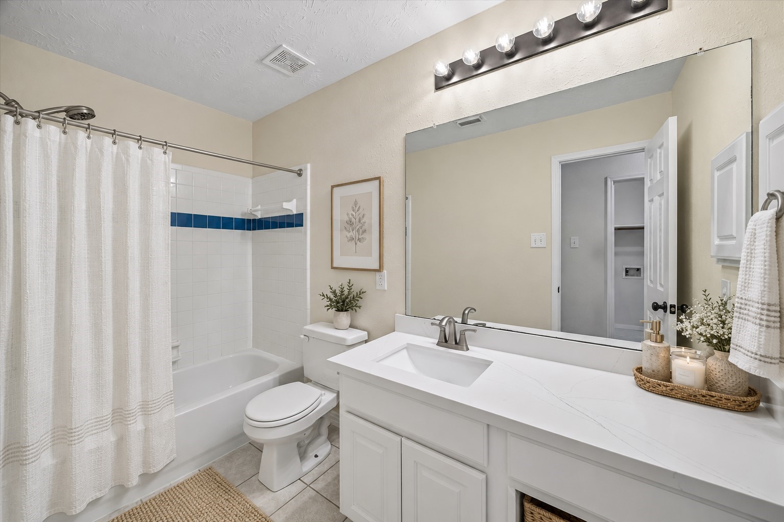 The secondary bathroom features a tub/shower combination and lots of countertop space! Virtually staged with accessories.