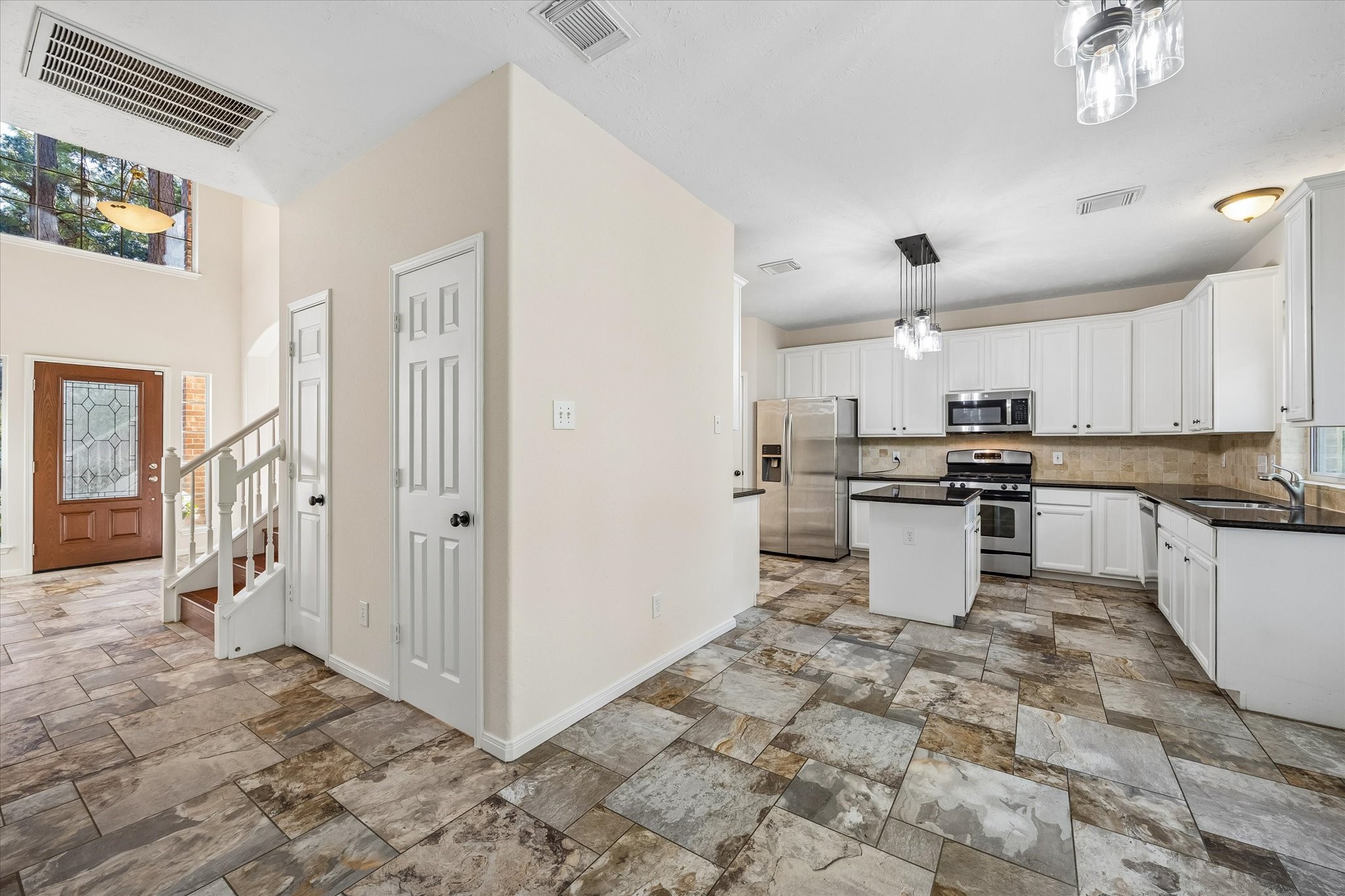 The thoughtfully designed layout allows the kitchen to flow effortlessly into the living space, while a conveniently located powder bath and additional storage closet sit just off the entryway for added functionality.
