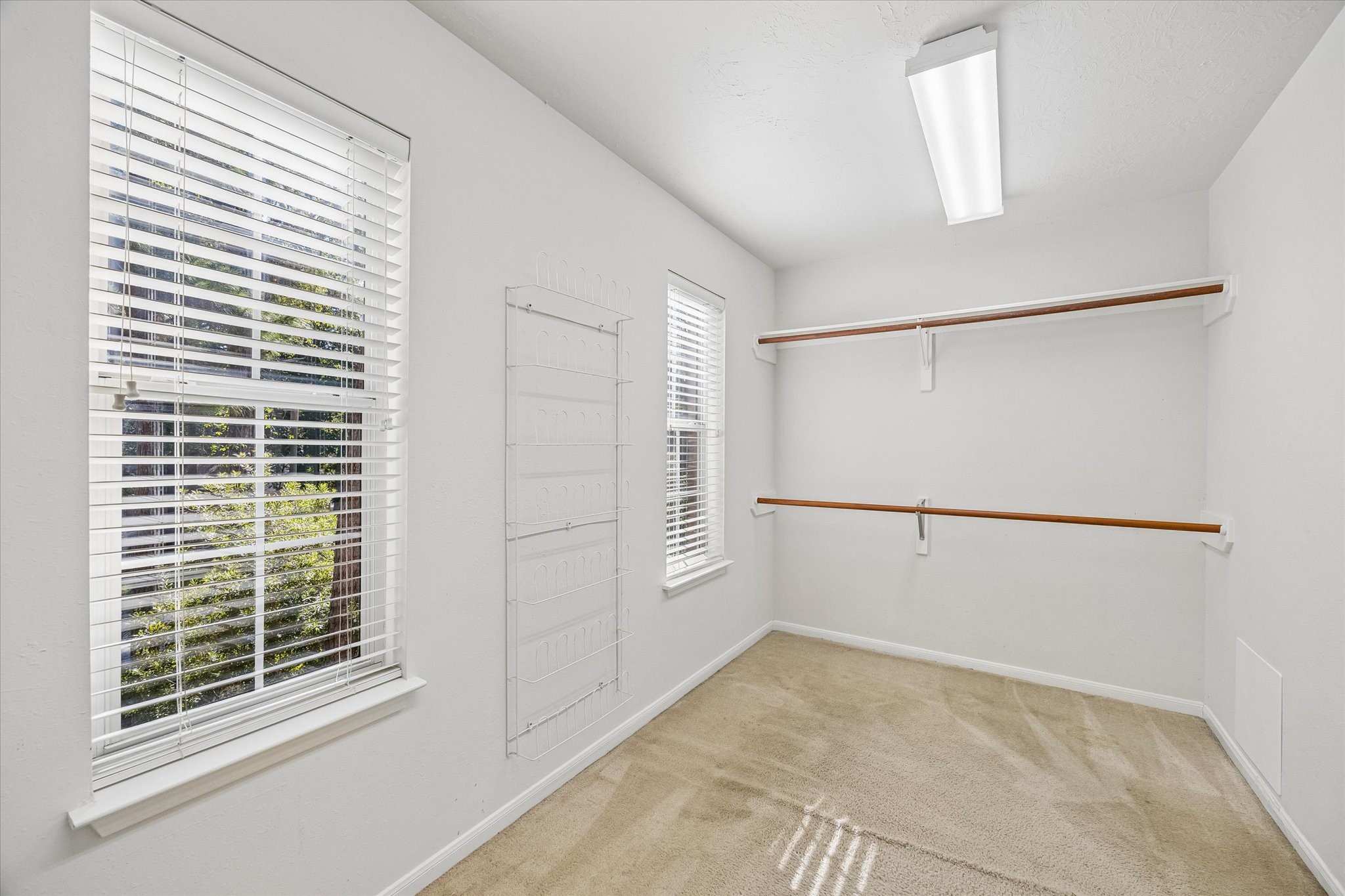 The spacious walk-in primary closet is conveniently located through the en-suite bathroom and features ample hanging space, built-in storage, and natural light.