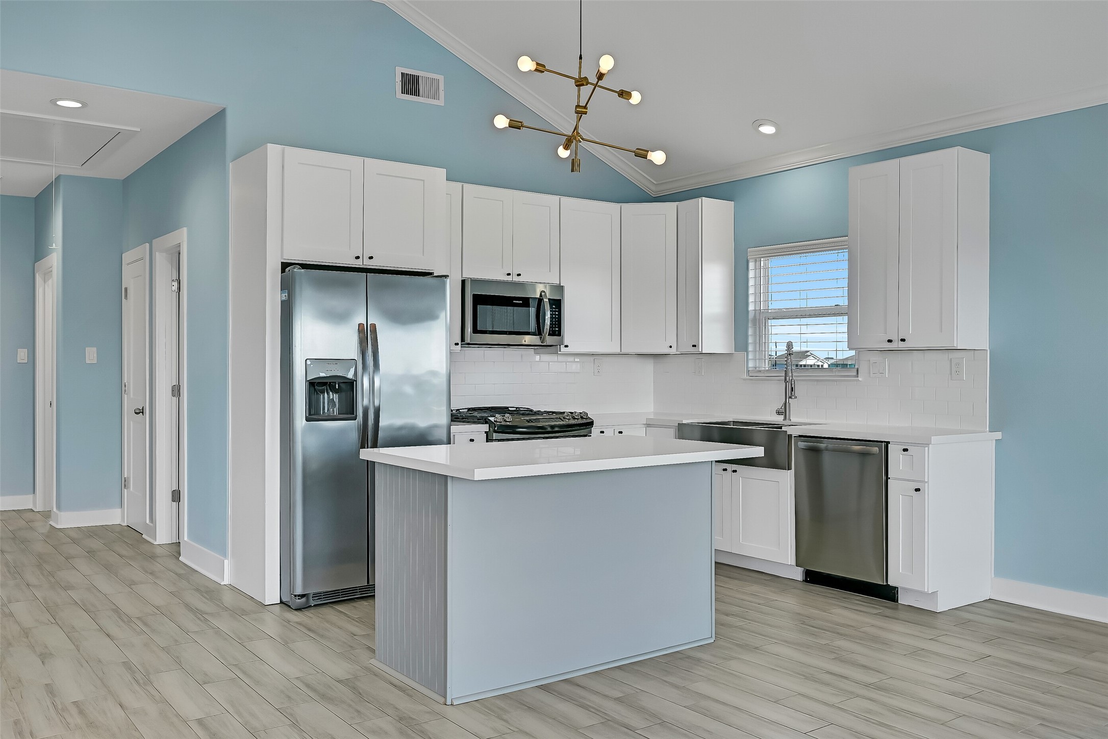 The kitchen is complete with quartz countertops,  and stainless steel appliances.