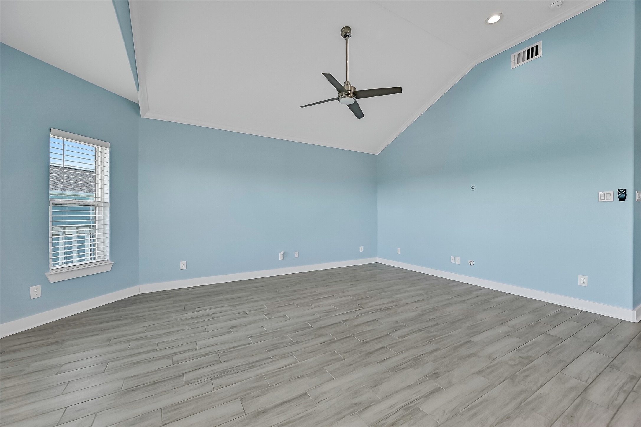 The living room boasts ample windows and soaring ceilings, creating a bright and open feel.