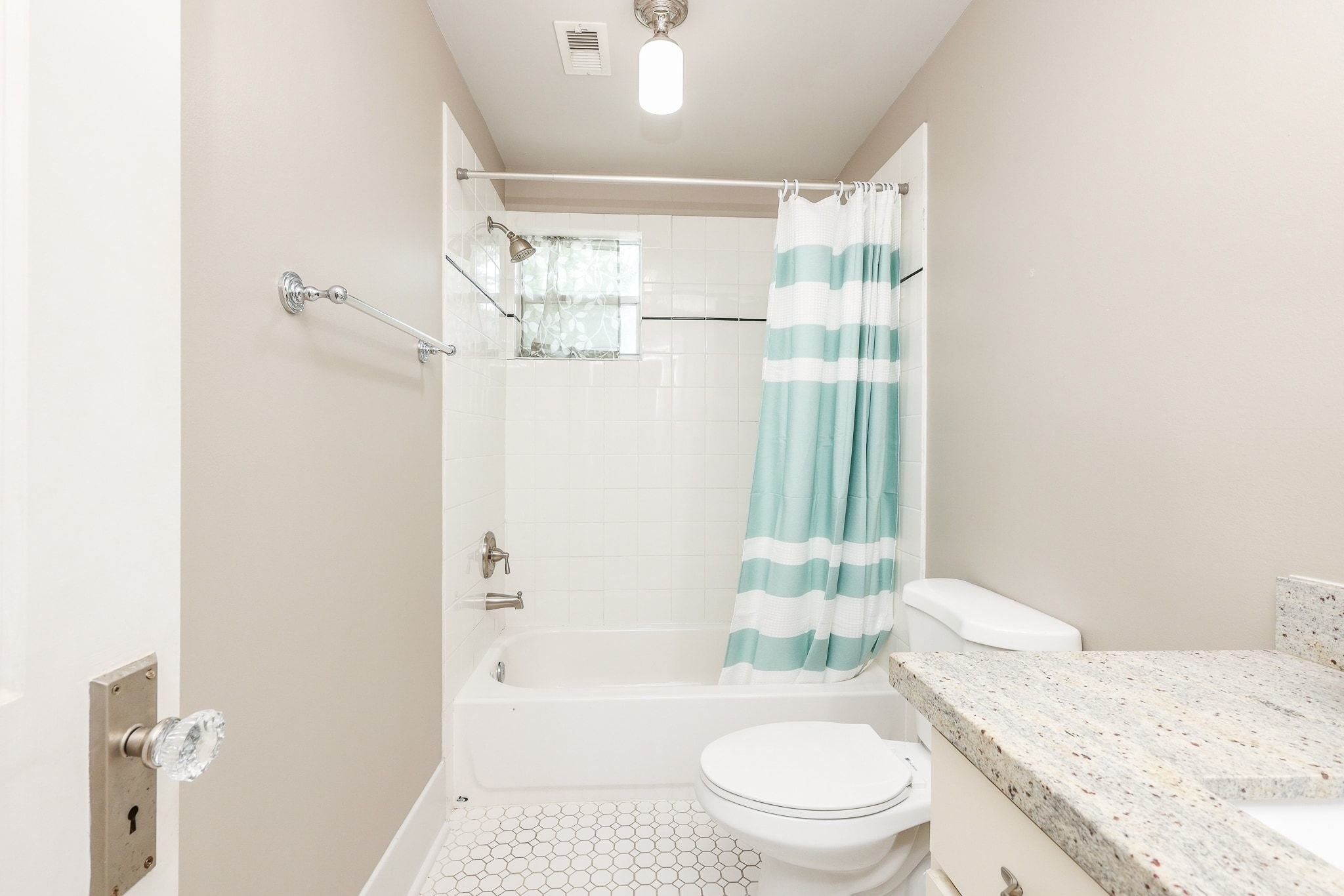 Full size hallway bathroom with tub/shower combination.