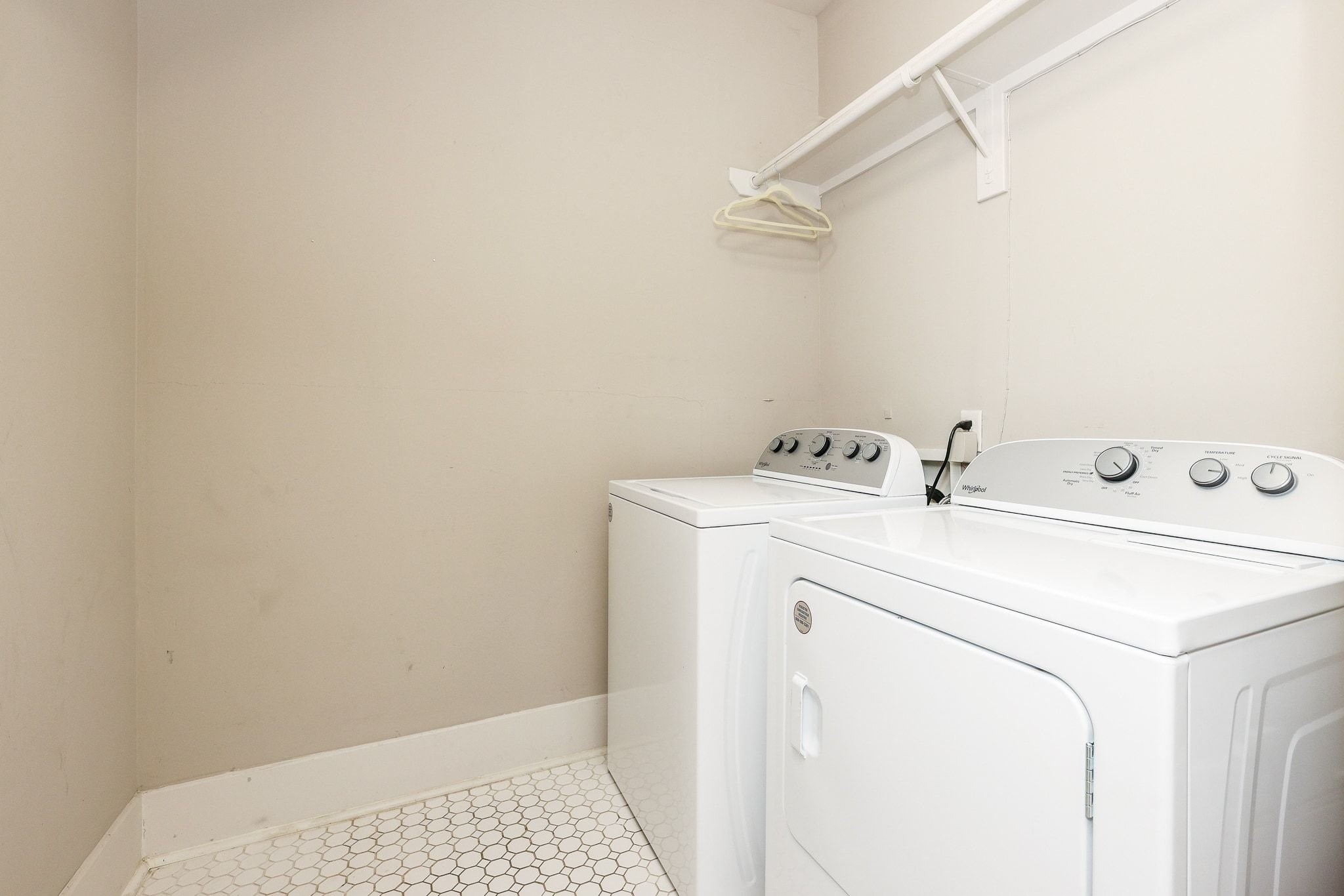Laundry space featuring tile flooring and a built-in storage shelf.