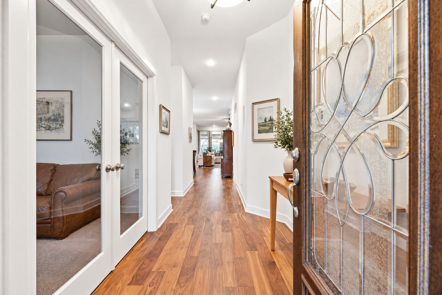 Inviting entryway through the elegant glass doors, warm wood floors. Virtually Staged