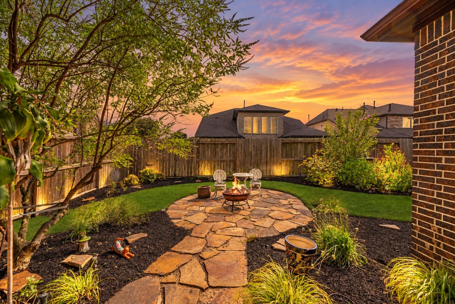 Step into backyard oasis featuring a flagstone patio perfect for a firepit and seating.