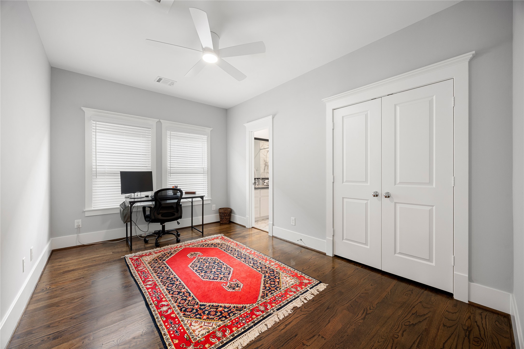 Additional upstairs bedroom offers hardwood floors, ceiling fan & flexible space for guests or a home office.