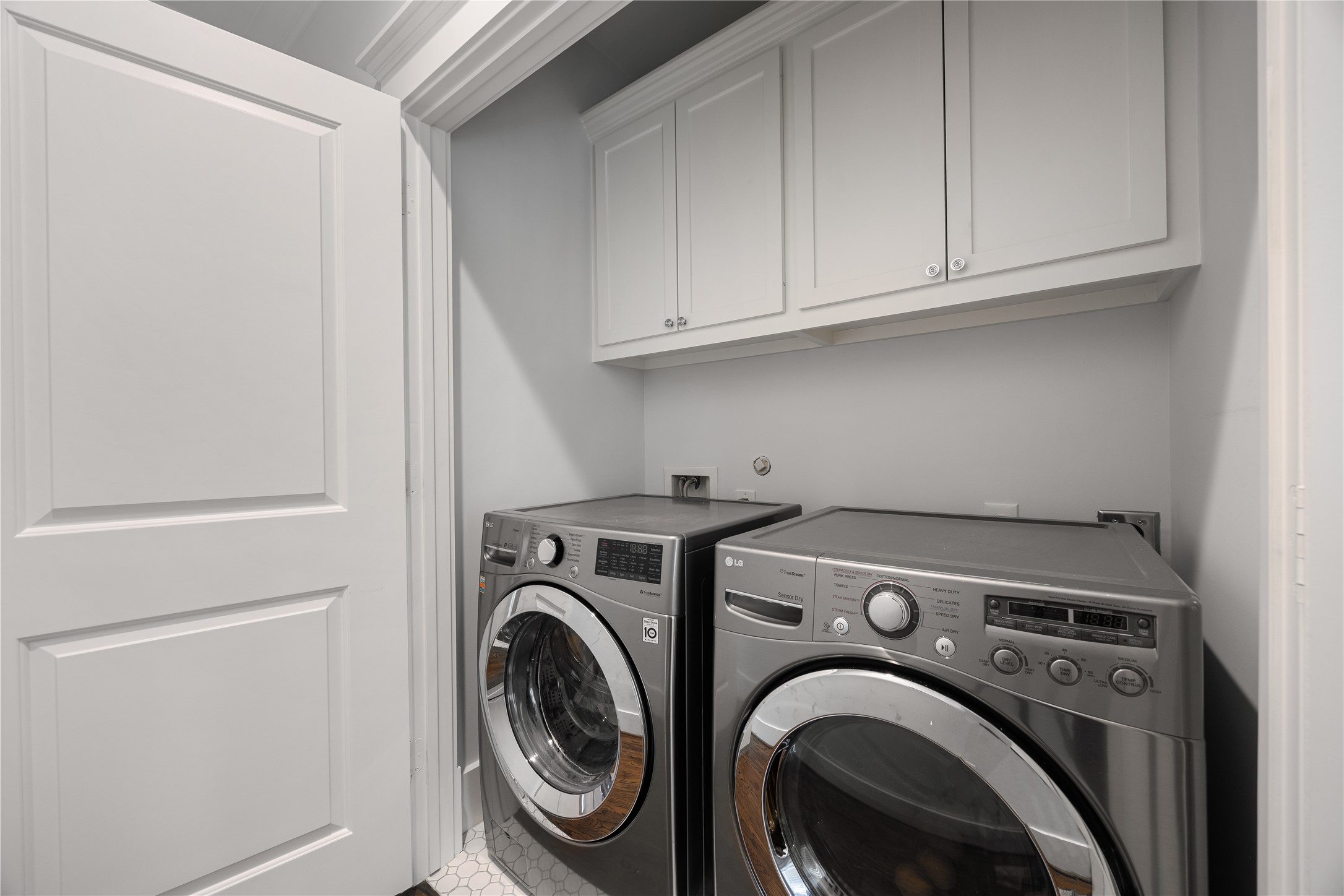 Convenient 2nd-floor laundry room includes cabinetry, storage & recent full-size washer and dryer.