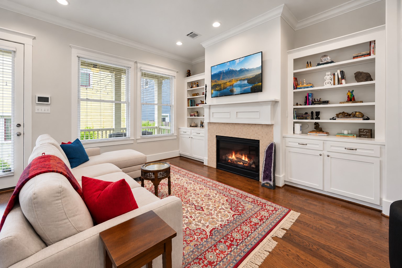 Inviting family room features a gas-log fireplace, custom built-ins, abundant natural light & an open connection to the kitchen.