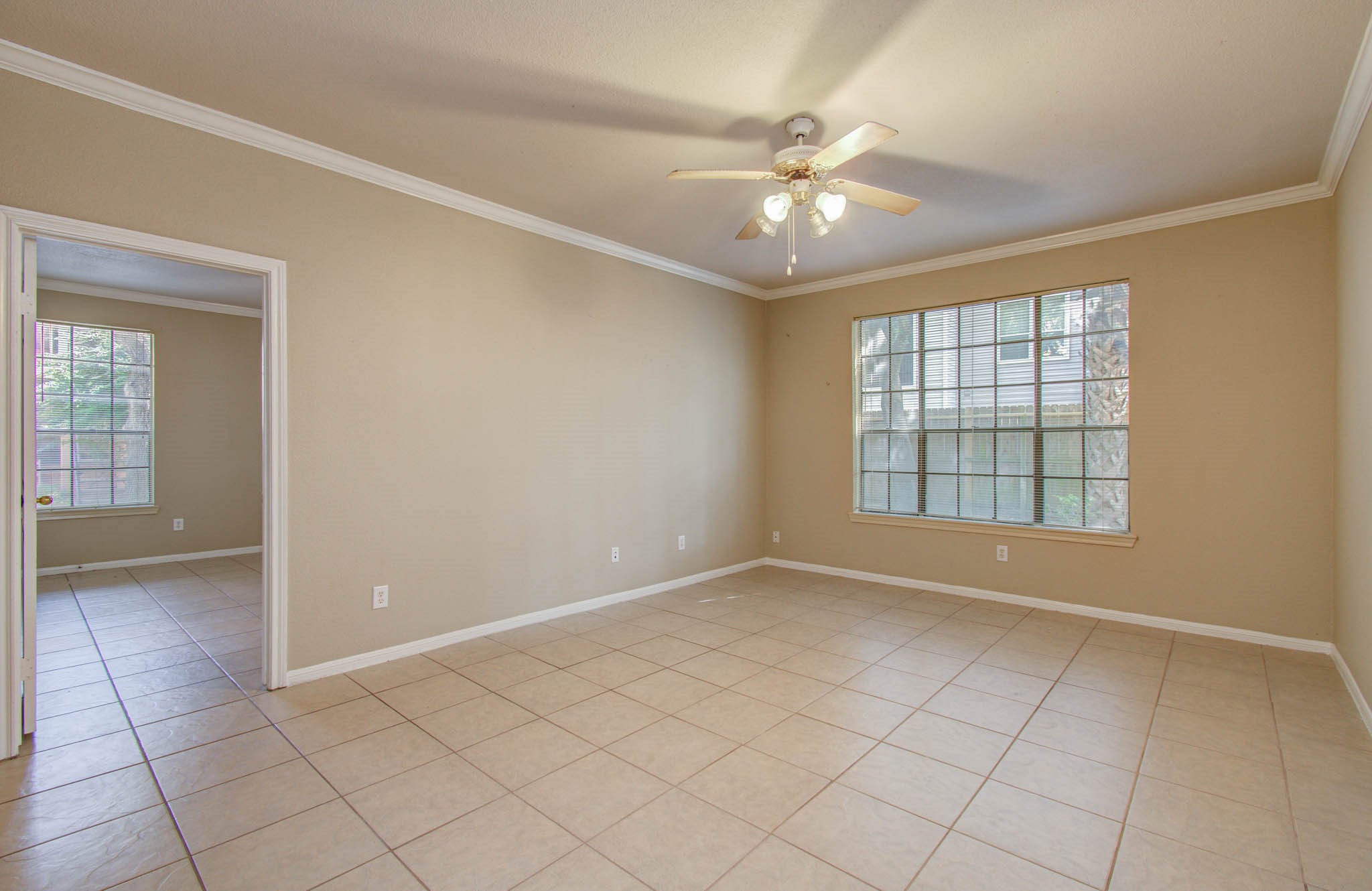 View of spacious living room featuring tile flooring, neutral walls, and large windows with plenty of natural light