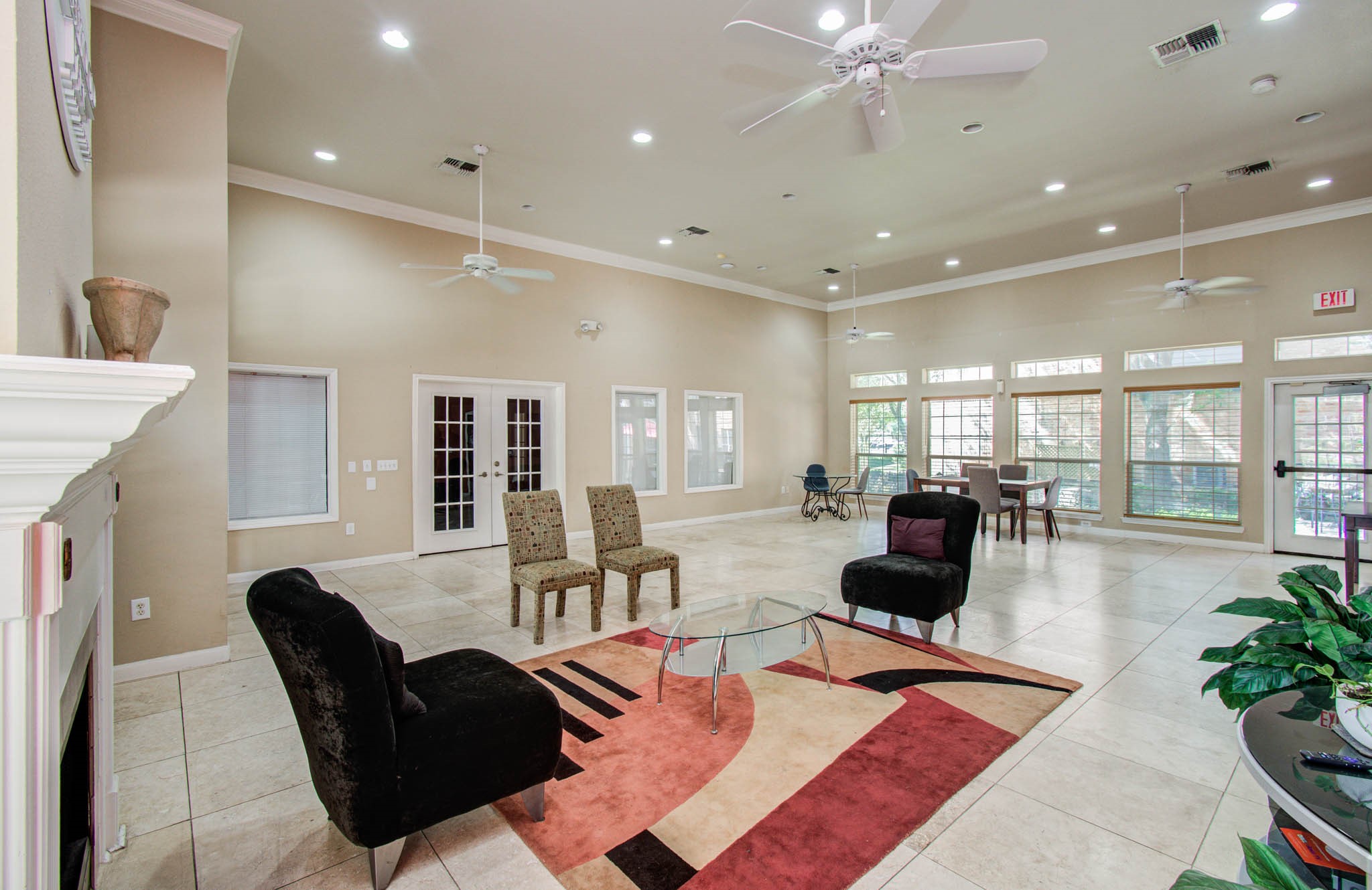 Another view of the clubhouse featuring a lounge setting with a modern rug and a glass coffee table, perfect for entertaining or relaxing.