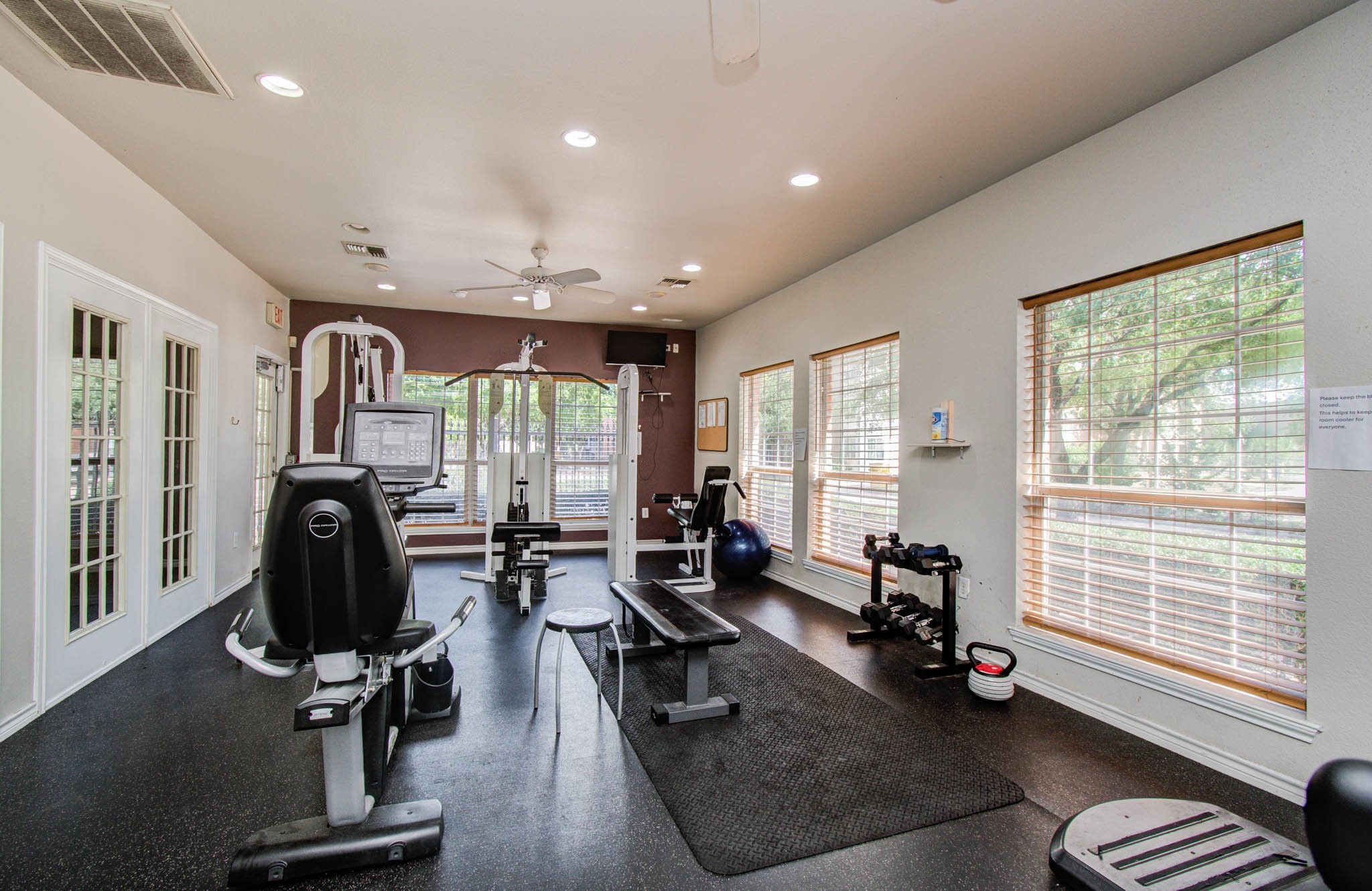 Another view of the well-equipped home gym with ample natural light from large windows, creating an inviting space for workouts.