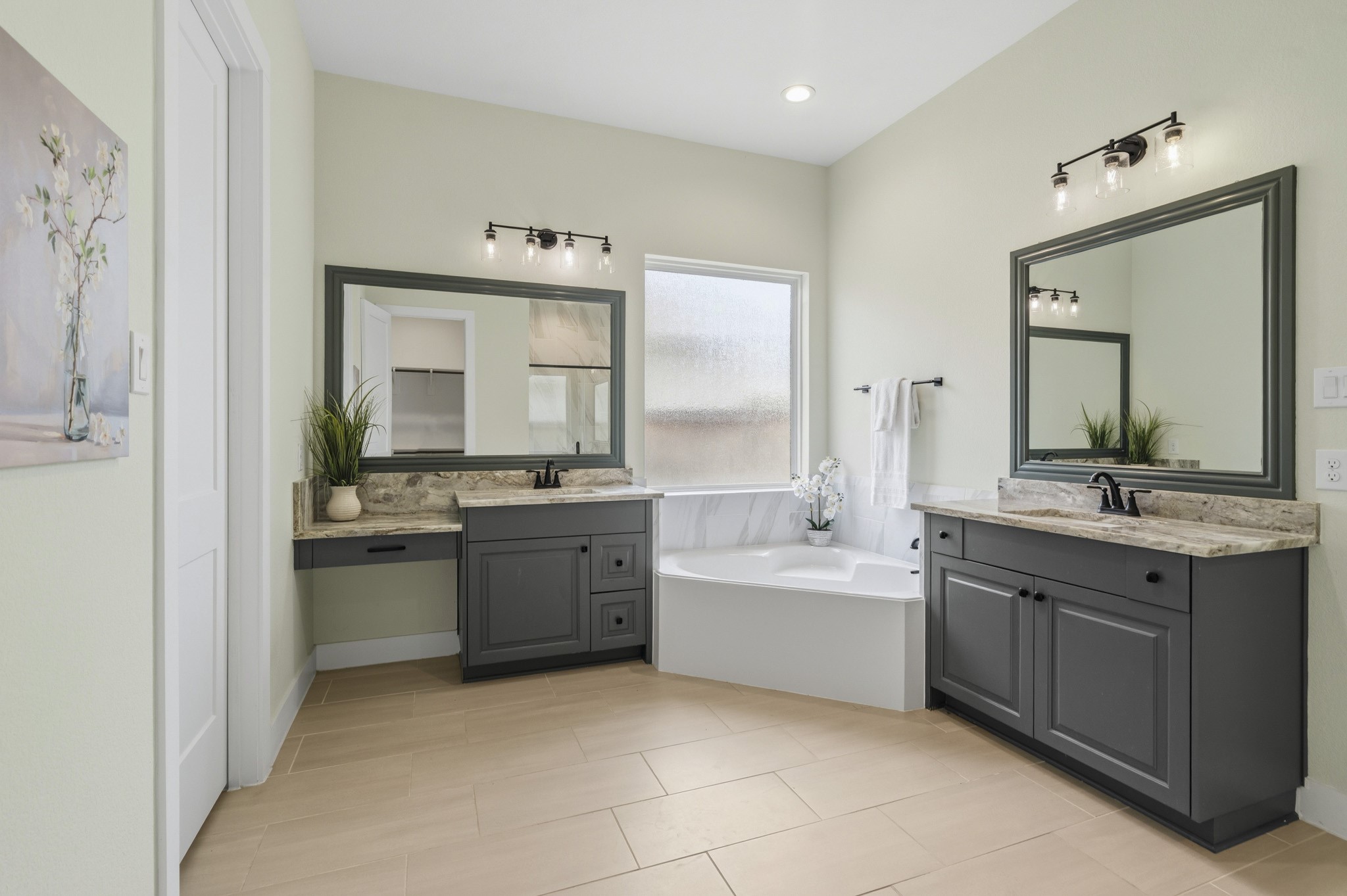 The Primary Bath exudes sophistication and timeless style, offering a spa like experience for daily relaxation. Thoughtfully appointed with dual vanities, a dedicated makeup vanity, and bathed in beautiful granite with under-mount sinks, custom framed mirrors and black cabinet hardware where every day detail has been carefully curated to blend luxury with functionality.