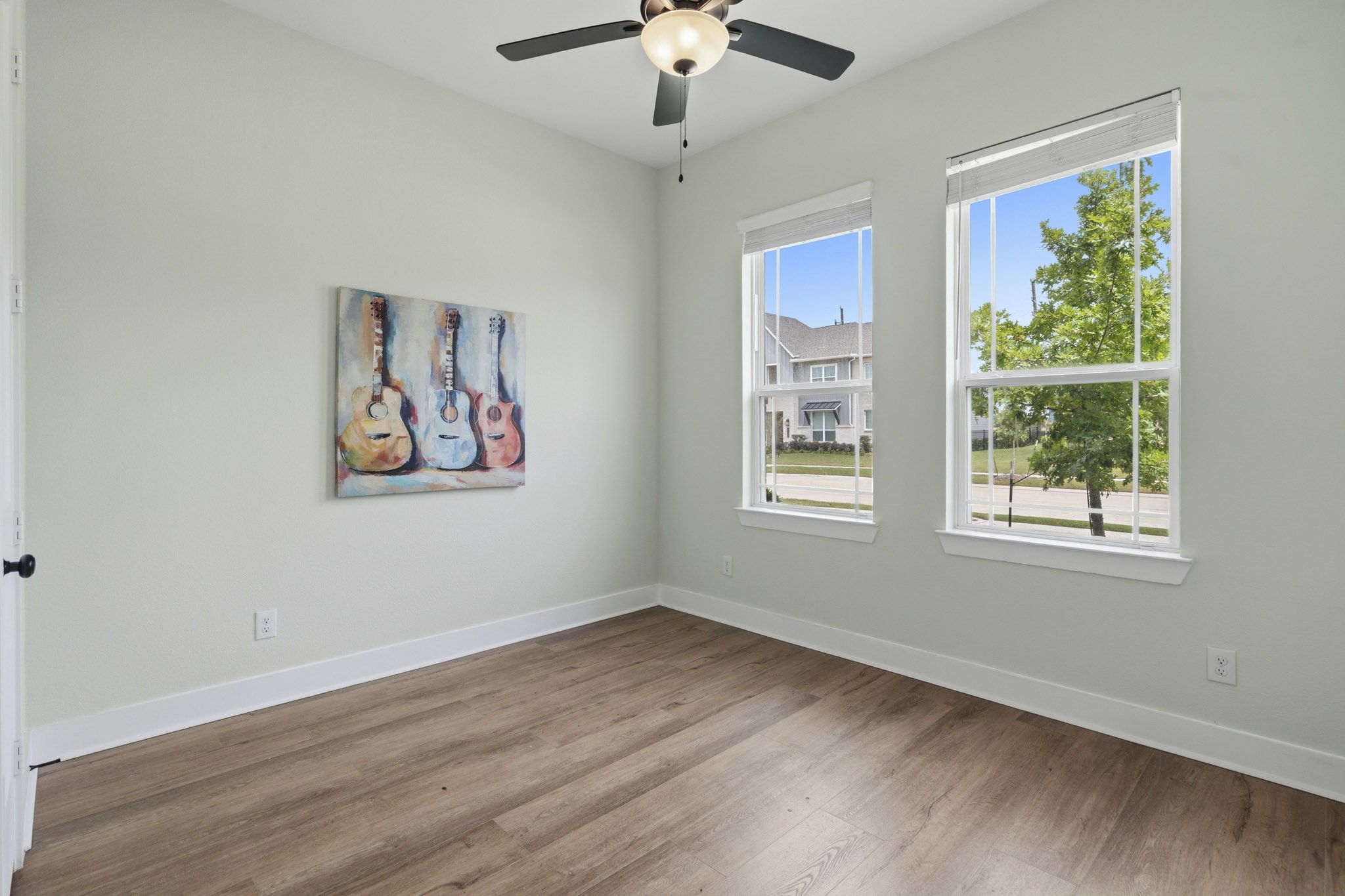 This light-filled Secondary Bedroom offers a warm and inviting space, featuring beautiful LVP flooring, two front yard-facing windows and a spacious walk-in closet for ample storage. Conveniently located down the hall, this room shares a centrally positioned Full Bath with another Bedroom.