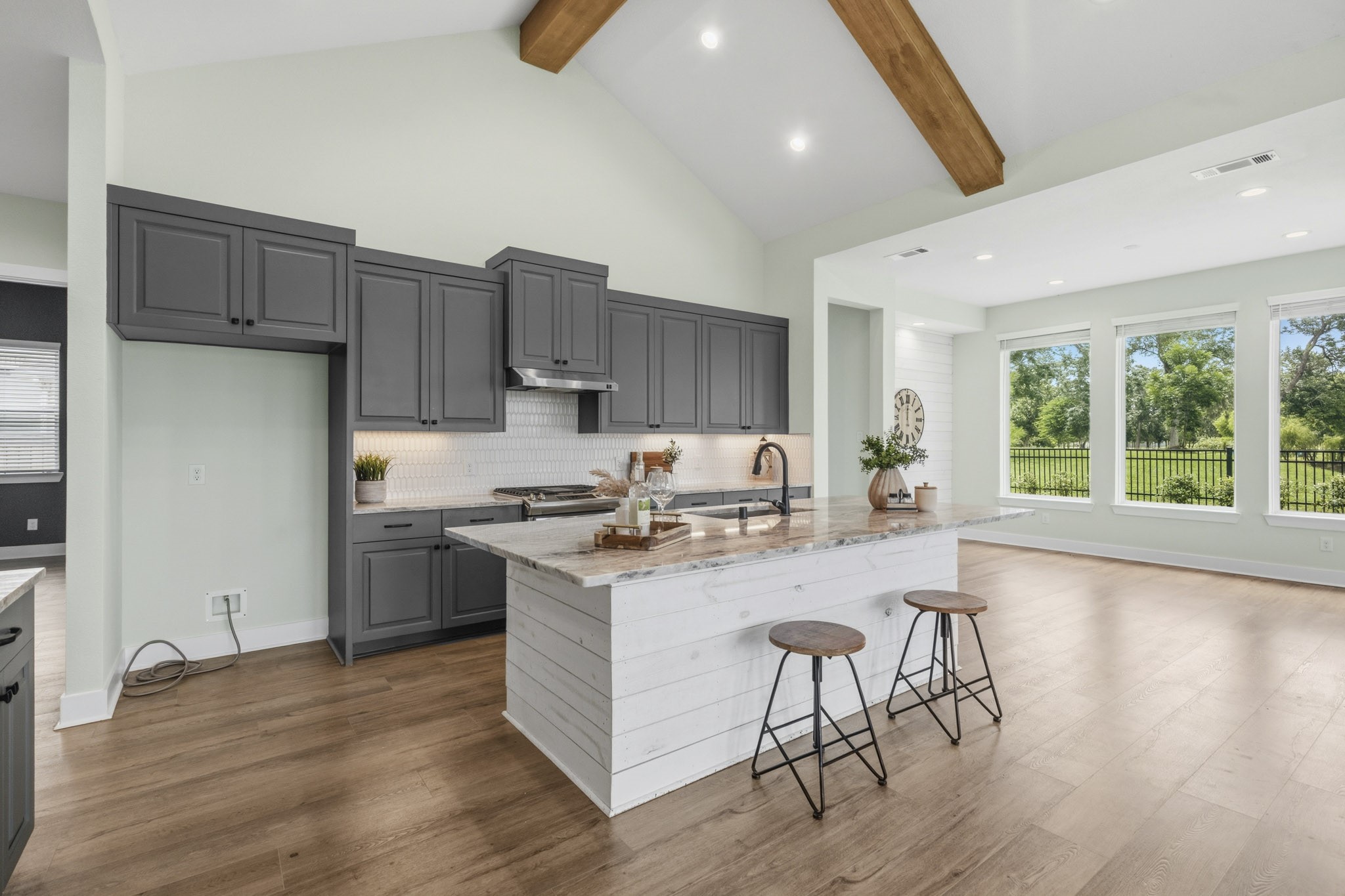 The center piece of the Kitchen is the large Island that is tastefully finished with a beautiful granite countertop and faced with hand-cut shiplap that coordinates with the beamed ceiling to warm the space and provide yet another custom detail.