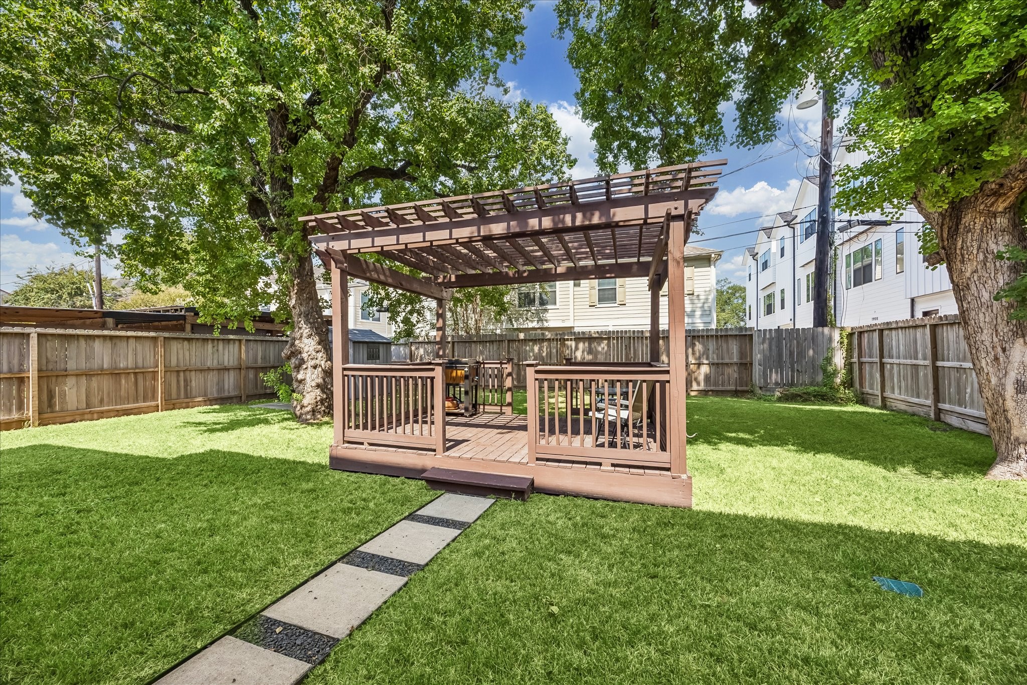 A second view of the pergola shows how it anchors the backyard while still leaving a generous stretch of open lawn.
