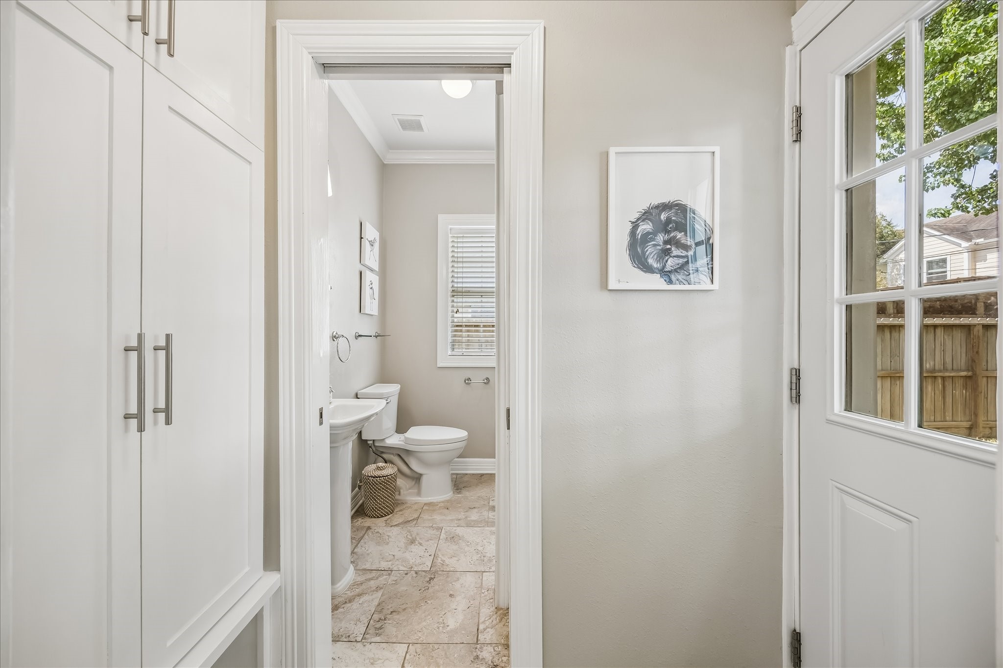 Built-in cabinetry adds useful concealed storage along the hall while keeping the adjoining spaces clean and uncluttered.