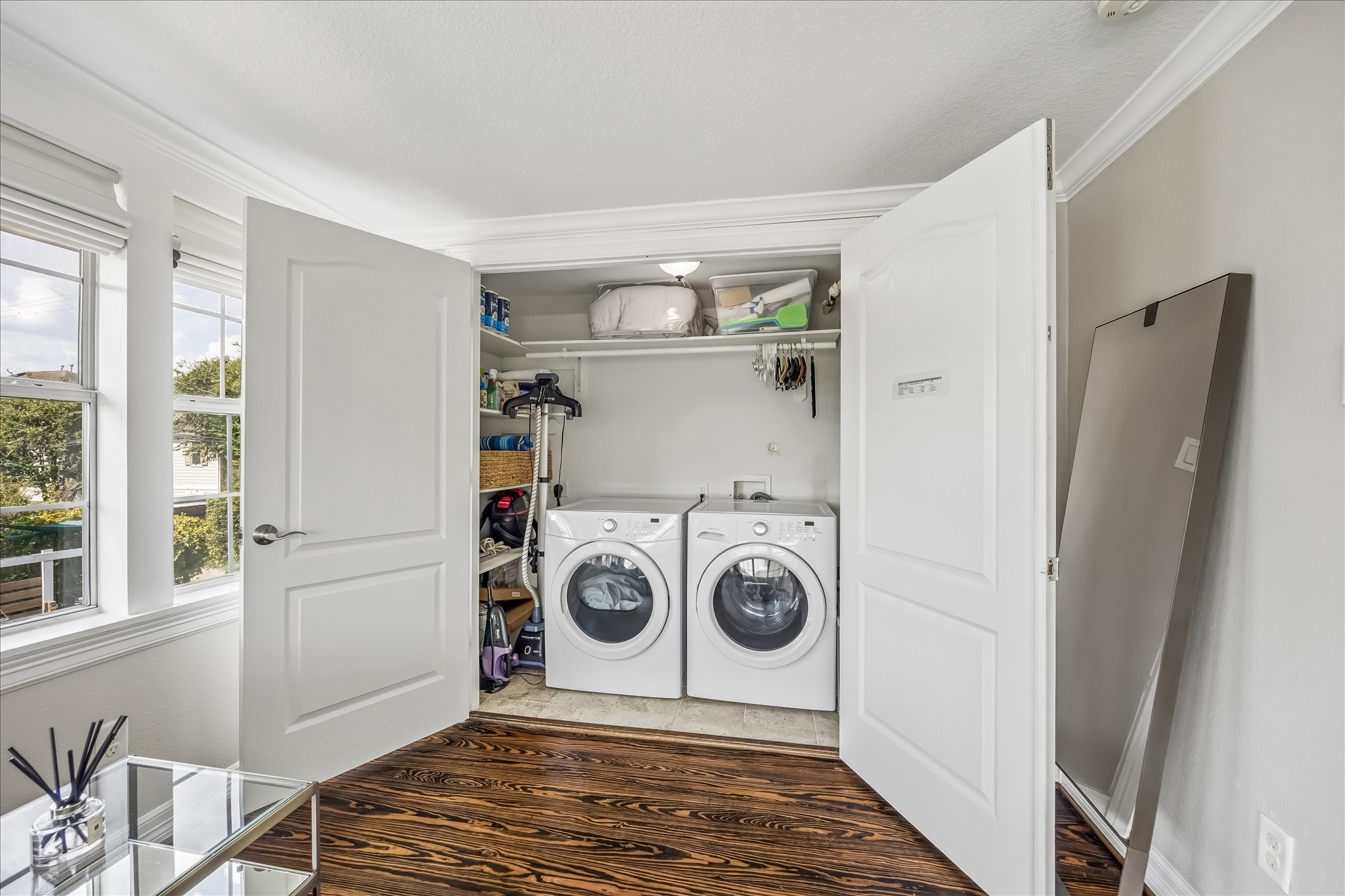 Dedicated utility room keeps laundry tucked away upstairs, with a side-by-side laundry setup, storage, and a window bringing in natural light.