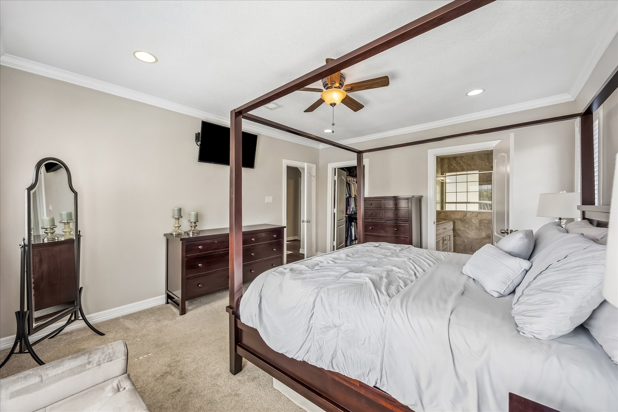 A second view of the primary suite shows the sitting area and easy connection toward the ensuite bath and walk-in closet.