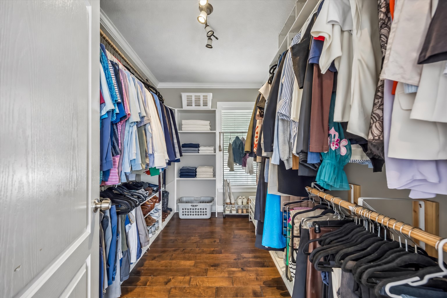 Walk-in closet provides long runs of hanging space, shoe storage, and built-in shelving while keeping everything neatly organized.