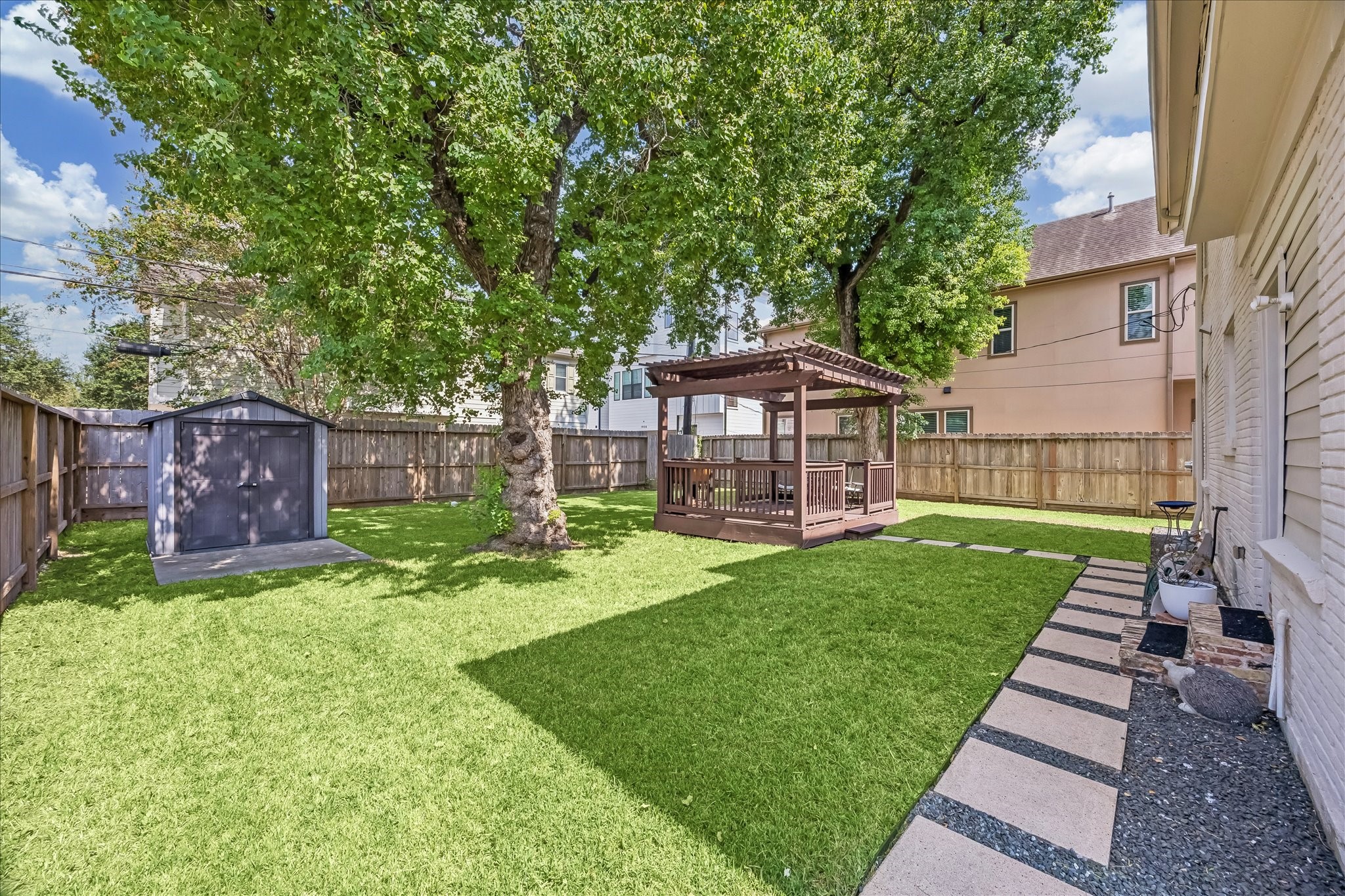Fenced backyard pairs open lawn with a paver walkway installed in 2020, along with French drainage added the same year.
