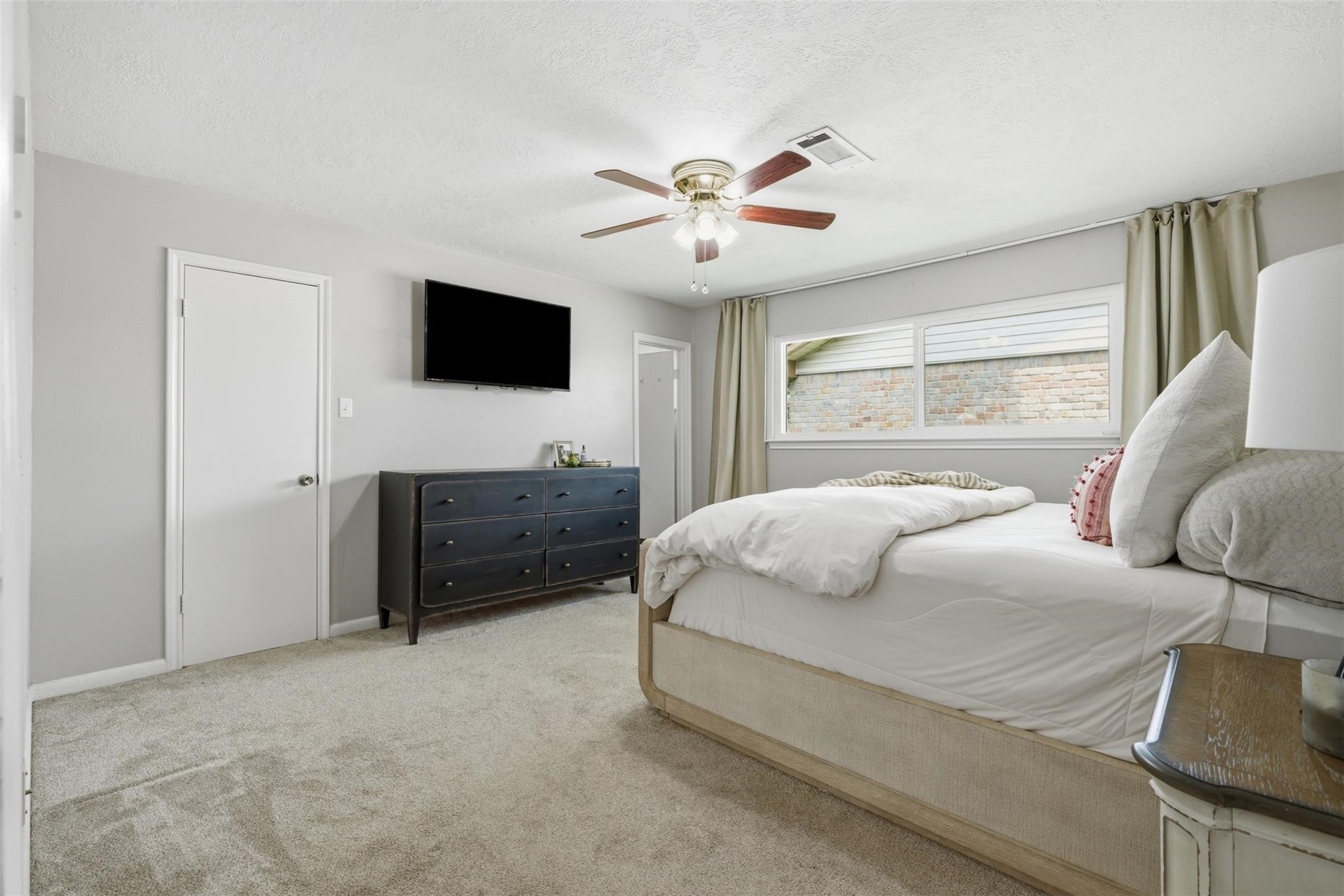 The spacious primary suite that fits a king bed, carpet installed (2021), and an en-suite bath.