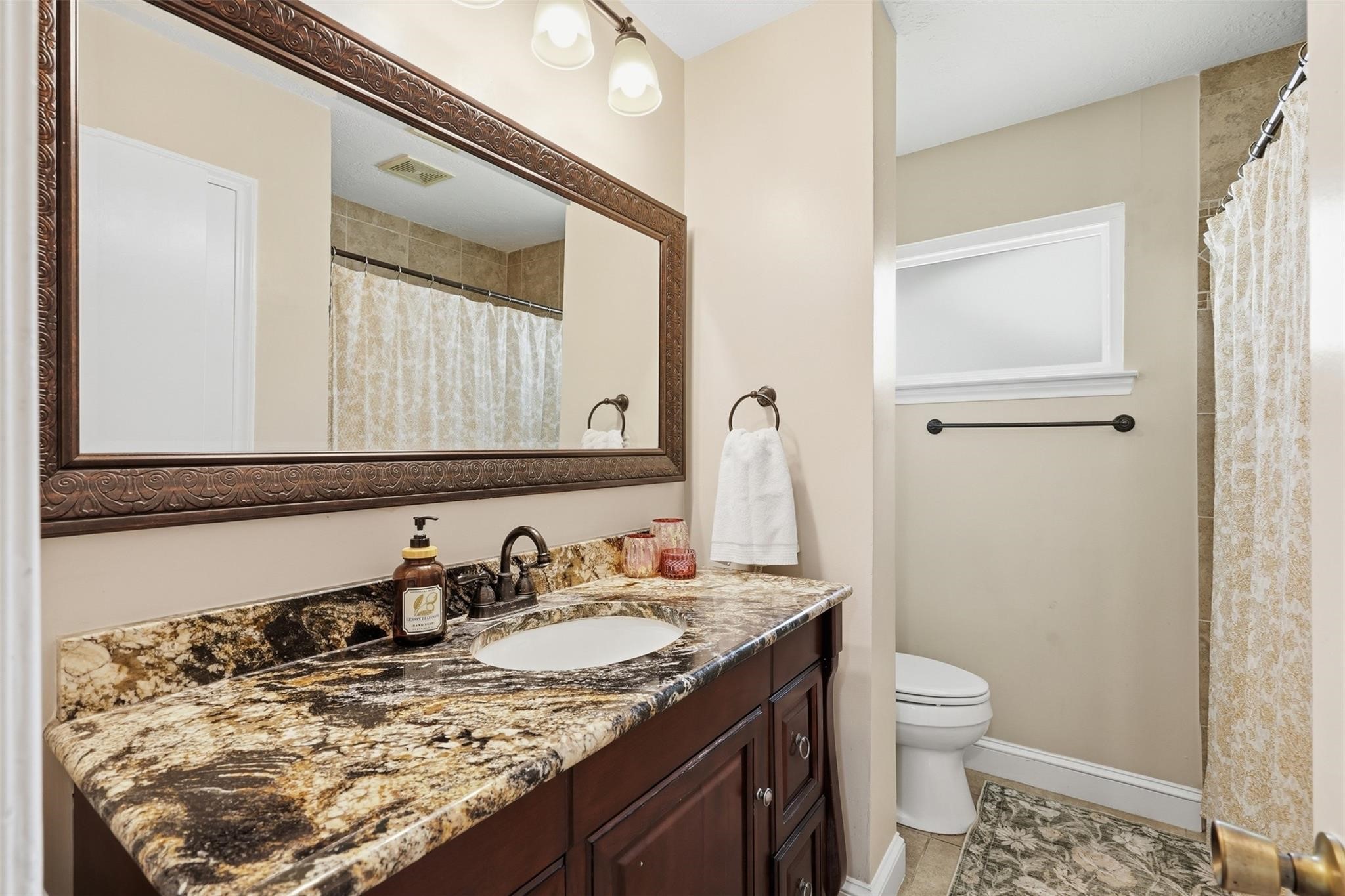 Hall / guest bathroom can be found just outside of the 3 bedrooms. This bathroom features a single vanity with granite countertops, and a tub/shower