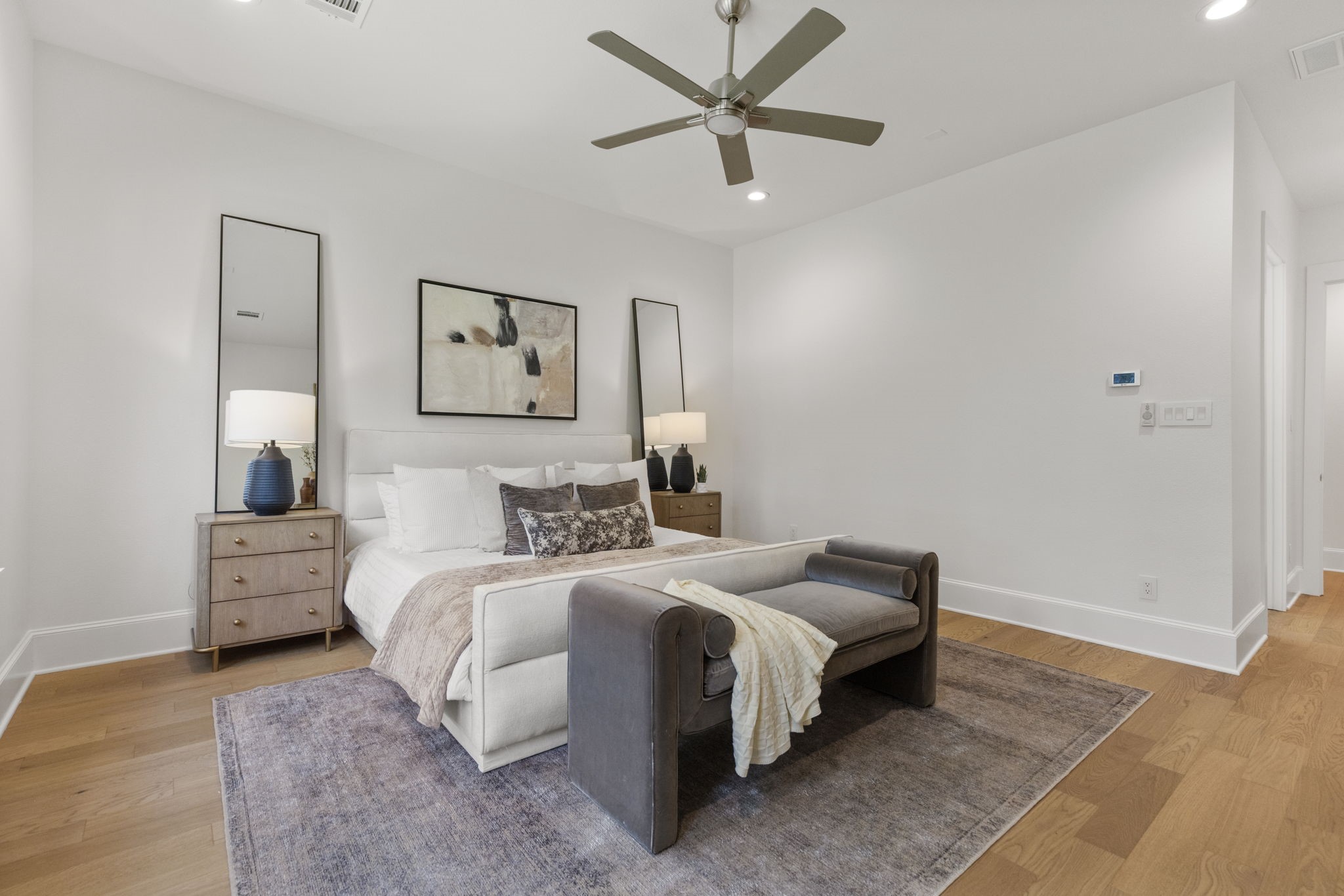 Experience the sophisticated elegance of the primary suite, featuring rich, character-filled wood floors and clean, designer white walls that offer the perfect versatile backdrop for any decor style.