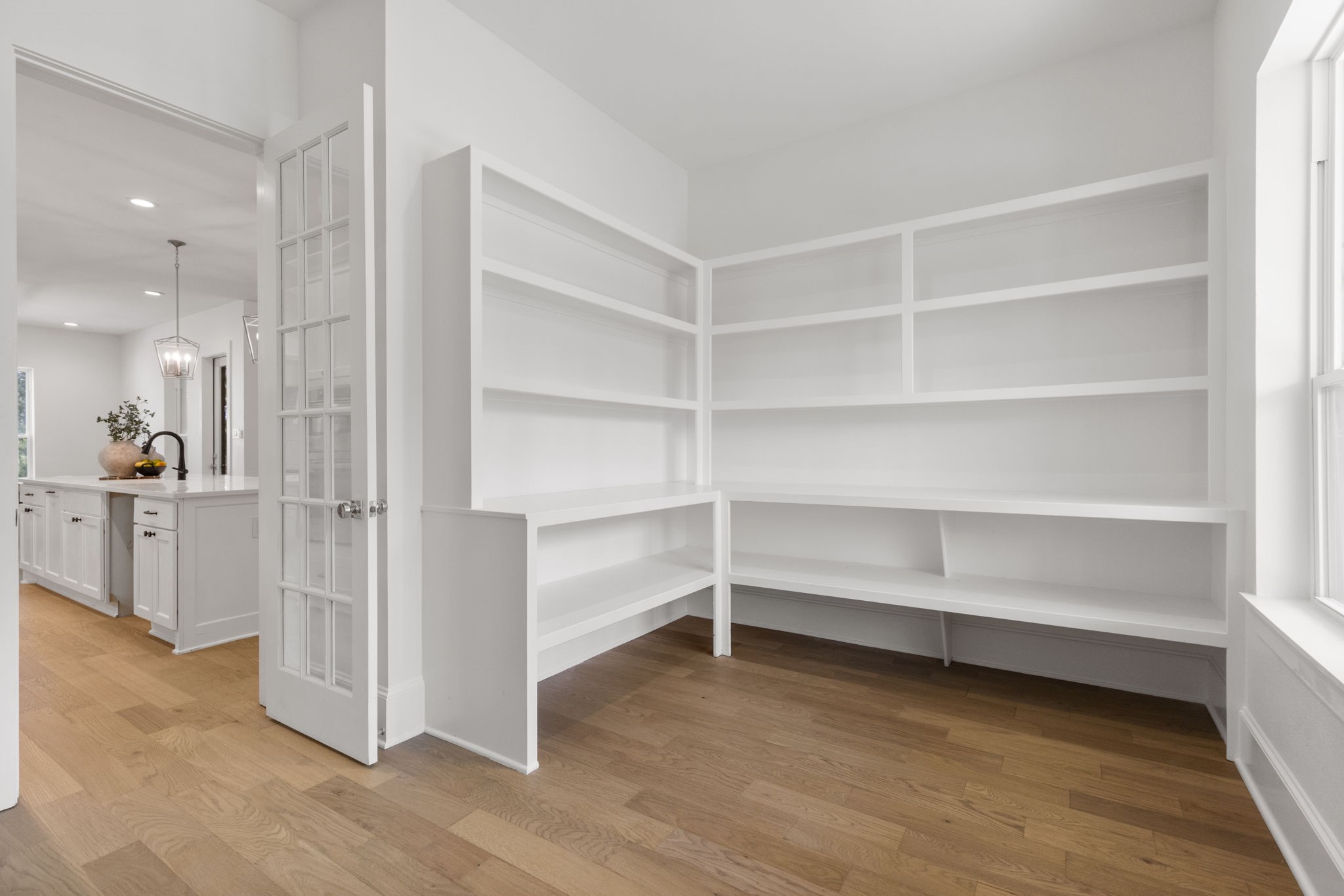 Dream pantry featuring spacious, custom shelving of varying depths, designed for optimal organization and dedicated storage for small appliances.