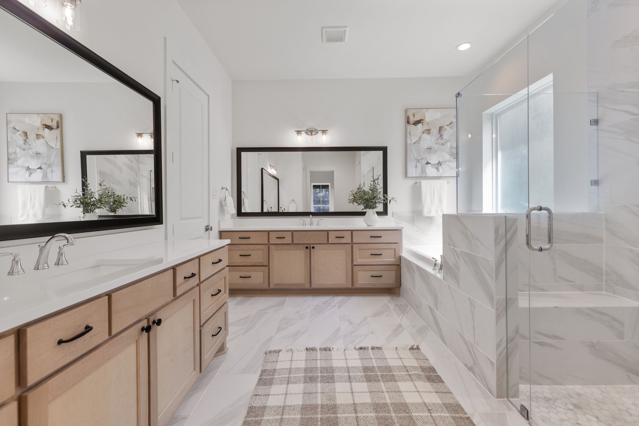 Fabulous primary ensuite featuring upscale finishes, dual vanities, a luxurious soaking tub, and a spacious walk-in glass shower.