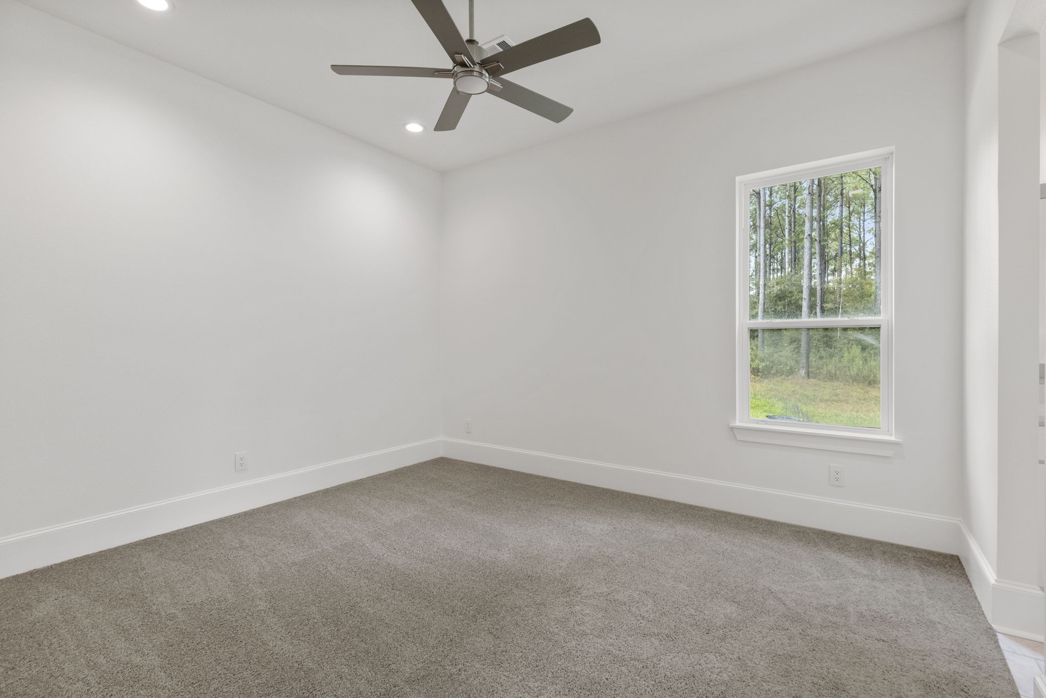 Bedroom three is spacious with beautiful views of trees, and has a convenient ensuite bath.