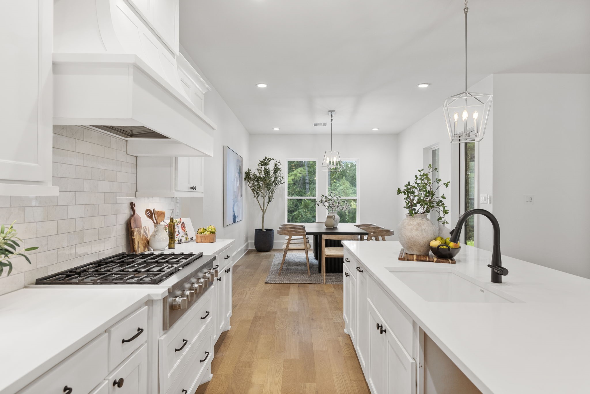 Professional gourmet kitchen featuring a high-end, 6-burner gas cooktop with a sleek, concealed vent hood.