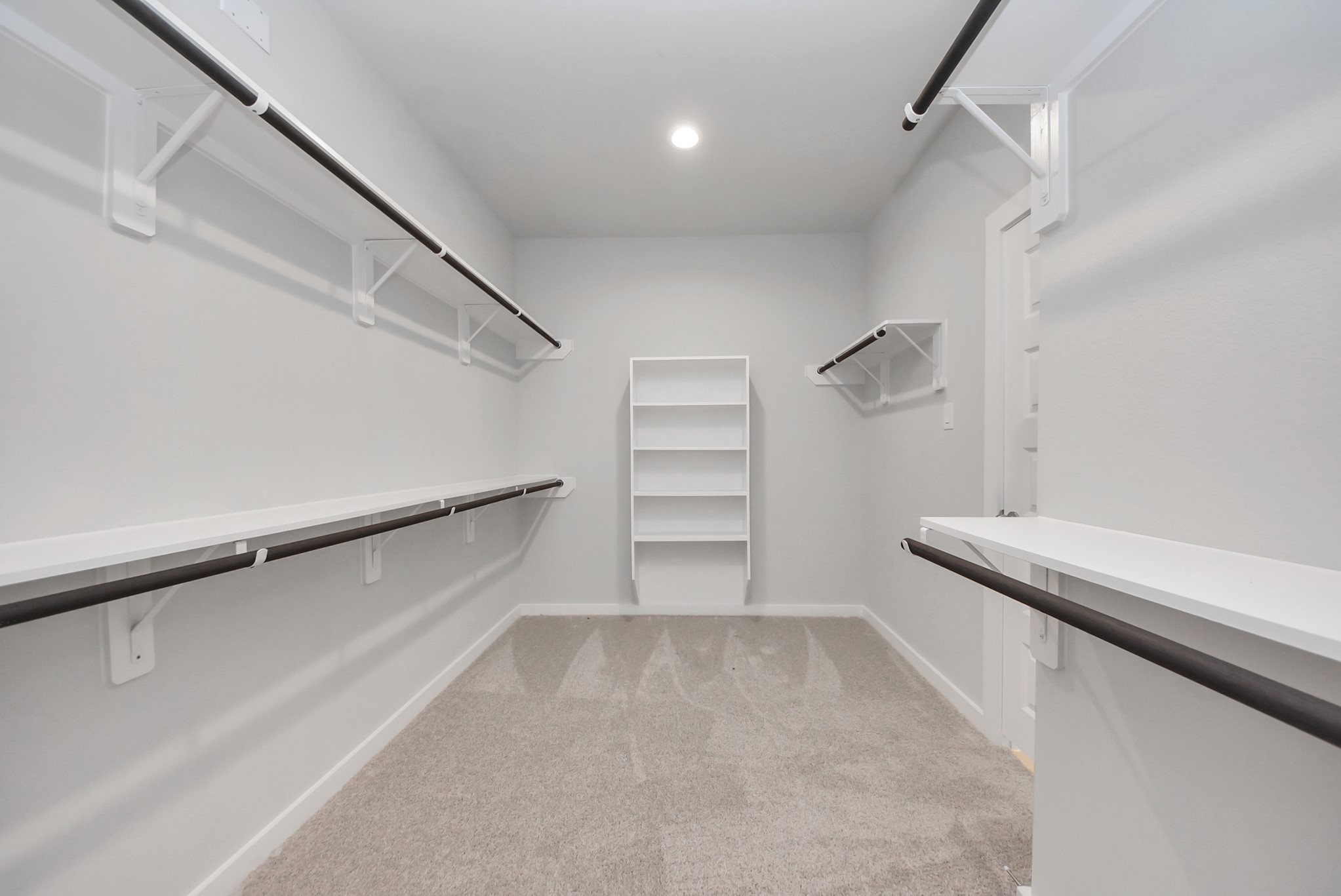 Walk-in closet that epitomizes luxury and practicality. This generously sized space features built-in shelving, offering abundant room for impeccable organization. High ceilings and recessed lighting create a bright and welcoming ambiance.