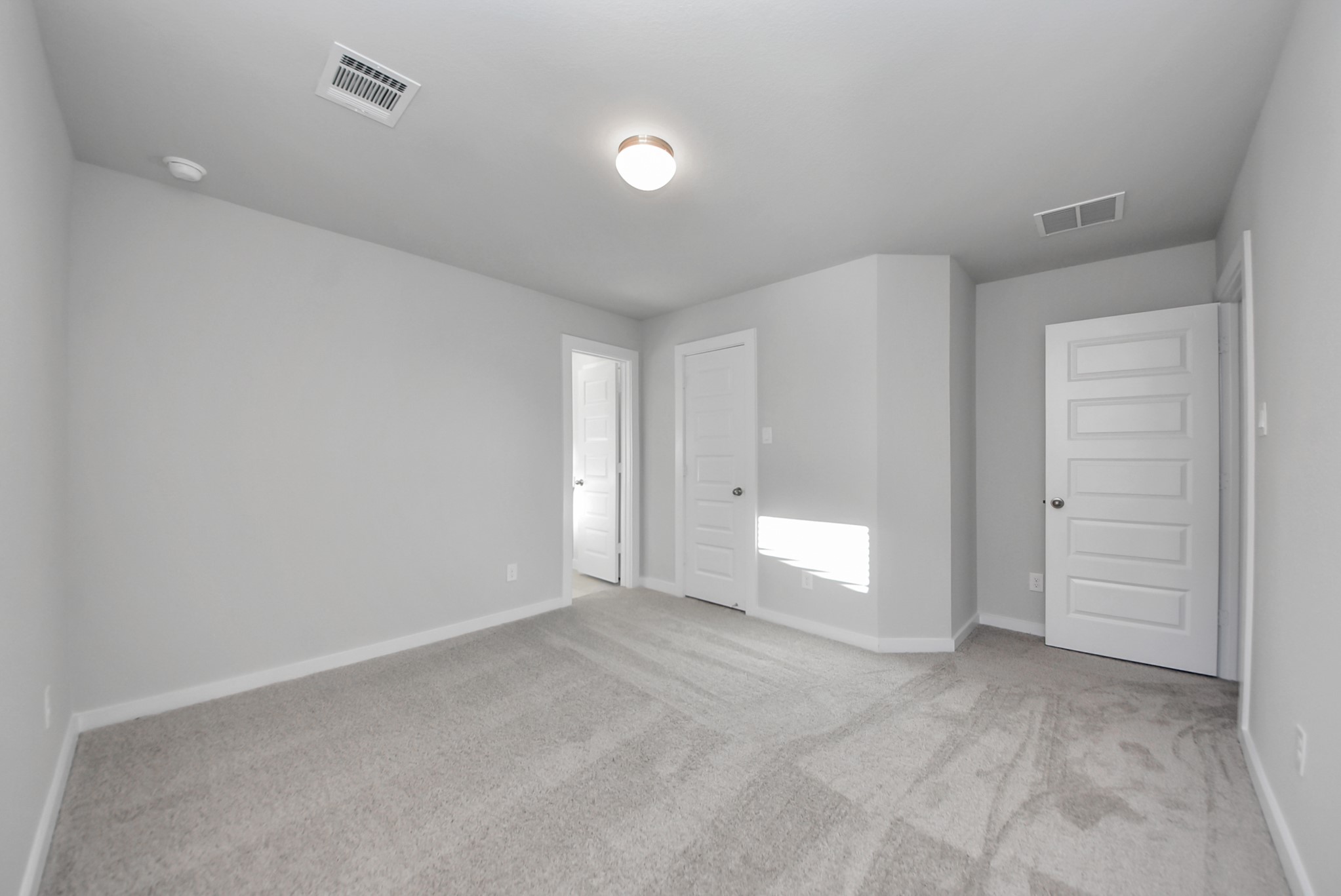 Secondary bedroom features plush carpeting, large windows that let in plenty of natural light, bright paint, and spacious closets.