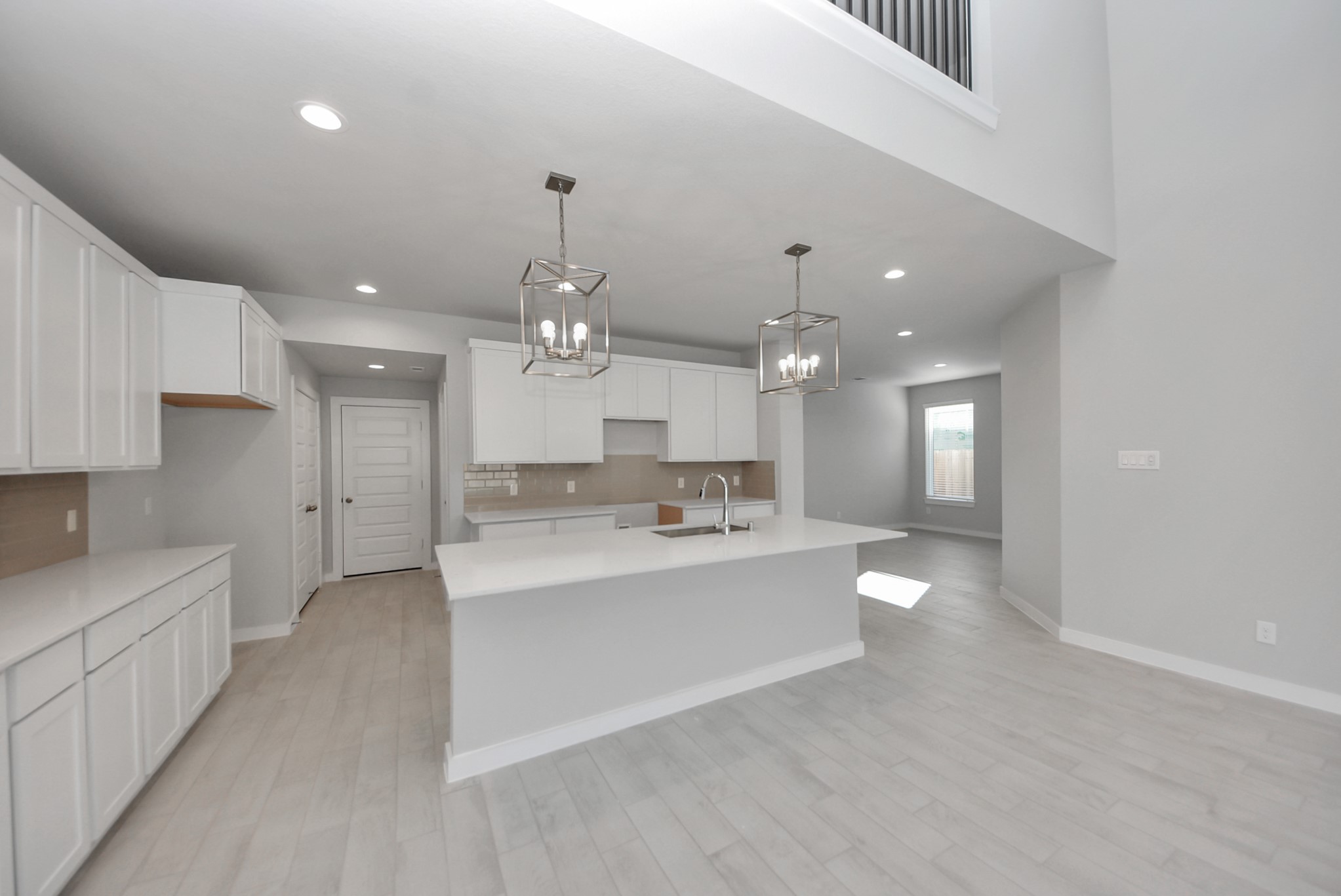 This kitchen is by far any chefs dream! This spacious kitchen features high ceilings, stained wood cabinets, granite countertop, SS appliances, modern tile backsplash, recessed lighting, extended counter space, granite kitchen island with double sink, and space for breakfast bar, and a walk-in pantry all overlooking your huge family room.