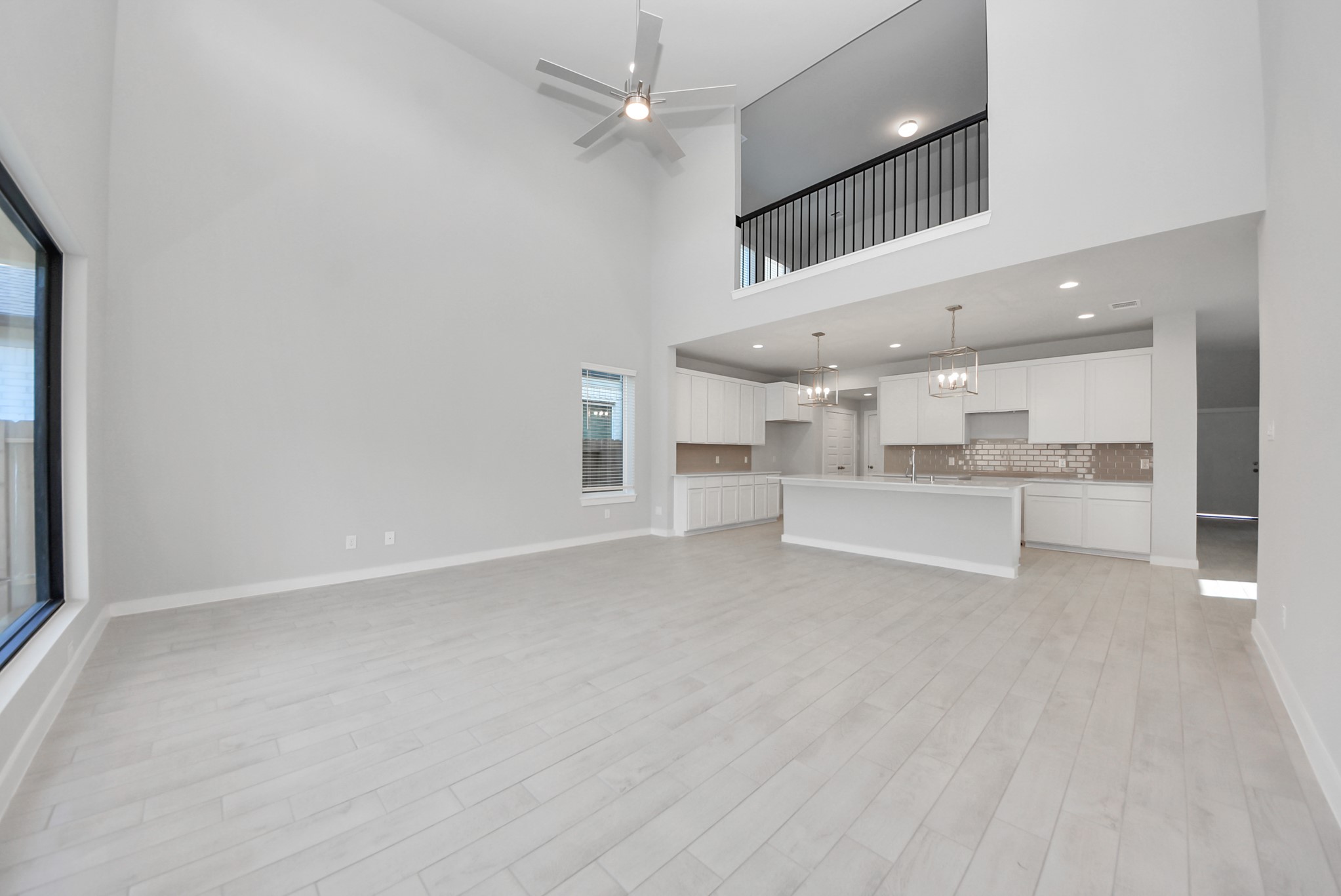 Family room flooded with natural light through the expansive windows.  The premium tile flooring adds a touch of luxury to the space, creating the perfect setting for relaxing moments and cherished gatherings with loved ones