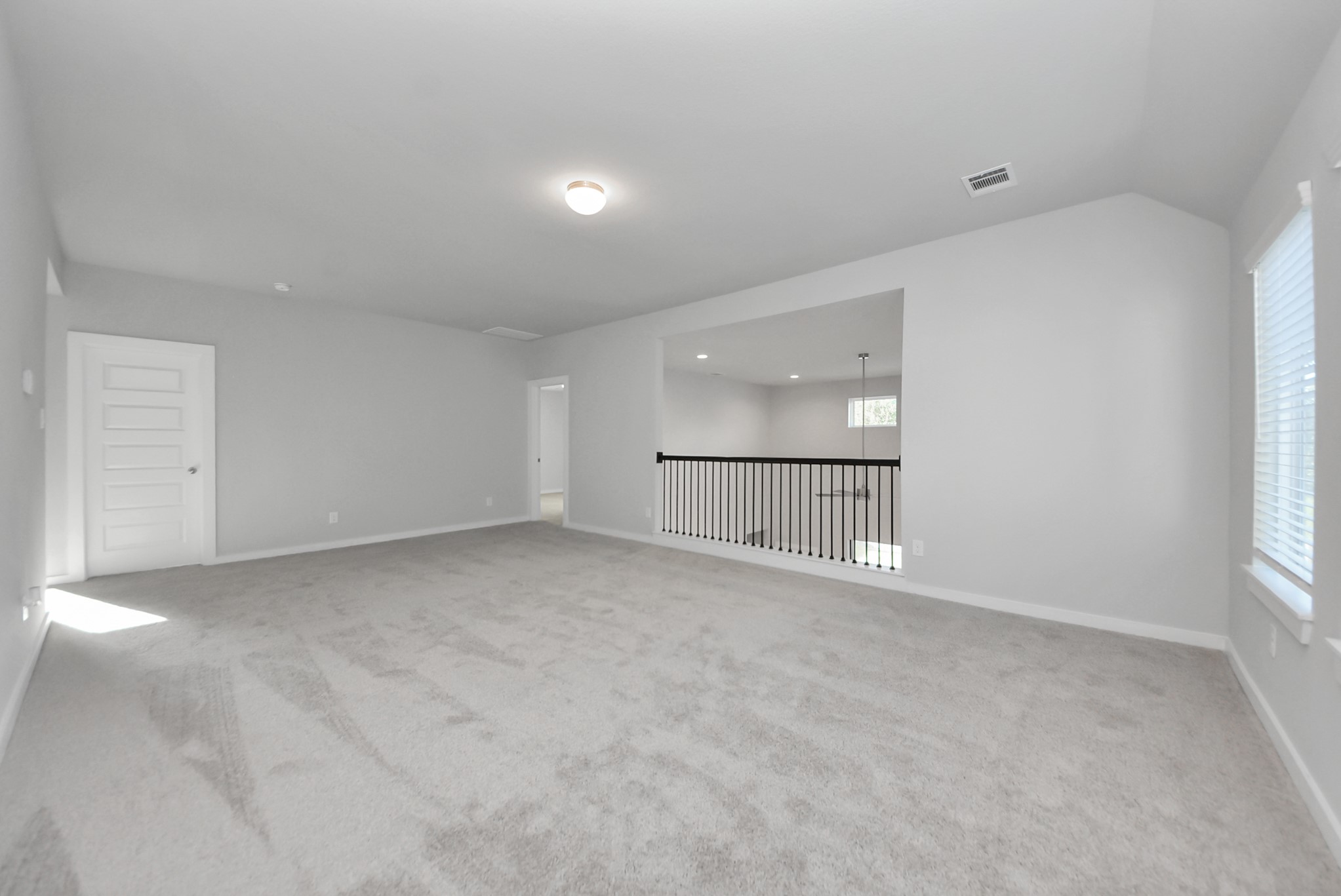 Discover a haven of leisure in this fantastic game room! Whether you're seeking a casual hangout or an adult gaming retreat, this space has it all. Enjoy the luxurious feel of plush carpet underfoot, the expansive ambiance of high ceilings, custom paint that adds a touch of personality, and windows that flood the room with refreshing natural light.