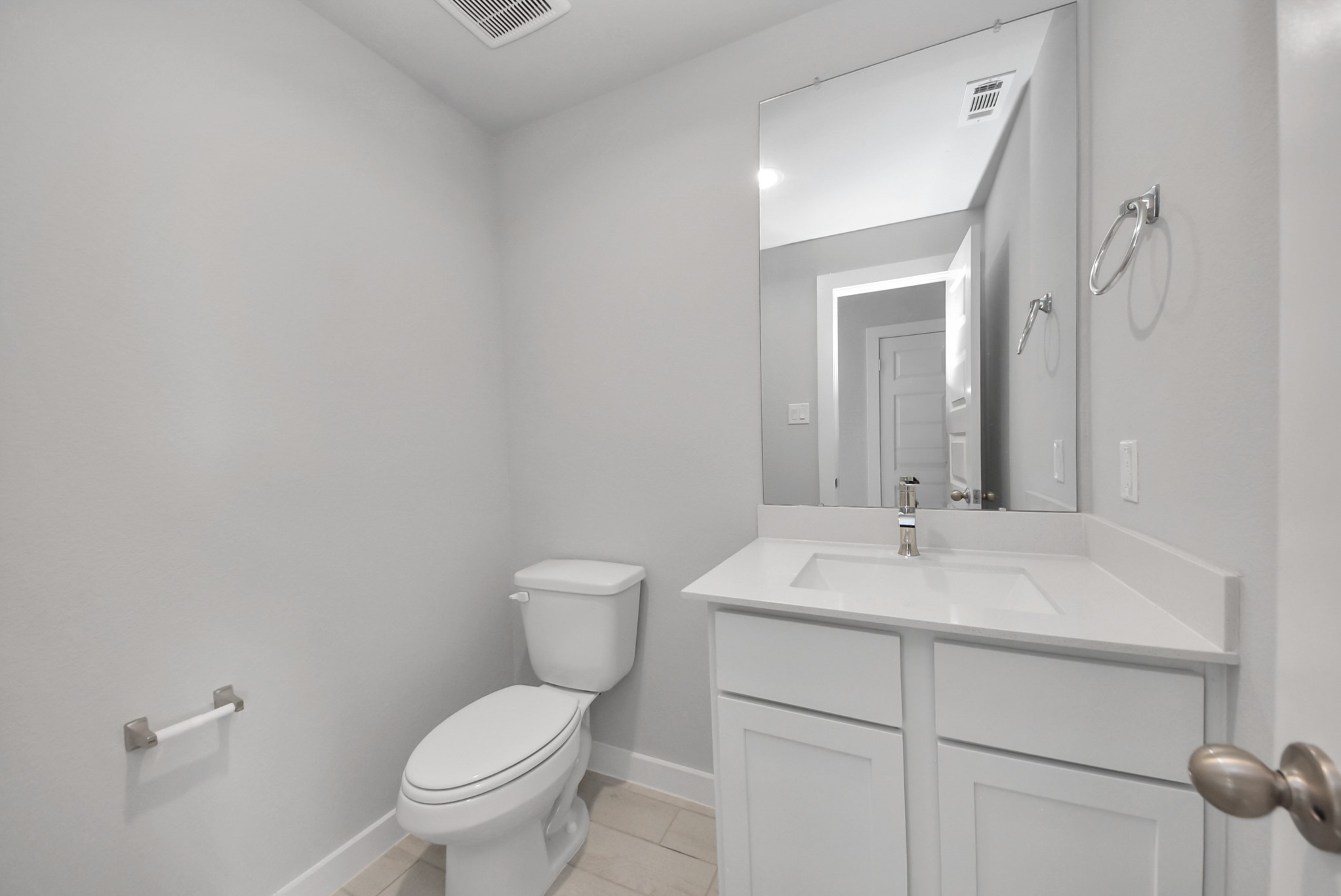Sophisticated half bathroom adorned with contemporary finishes. The elegant 5-panel door welcomes you to a space where style meets functionality. Notice the sleek hardware accents that add a touch of modern charm. The vanity boasts light-colored countertops, beautifully complemented by a tasteful vanity light, creating a well-lit and inviting atmosphere. Sophisticated half bathroom adorned with contemporary finishes. The elegant 5-panel door welcomes you to a space where style meets functionality. Notice the sleek hardware accents that add a touch of modern charm. The vanity boasts light-colored countertops, beautifully complemented by a tasteful vanity light, creating a well-lit and inviting atmosphere.