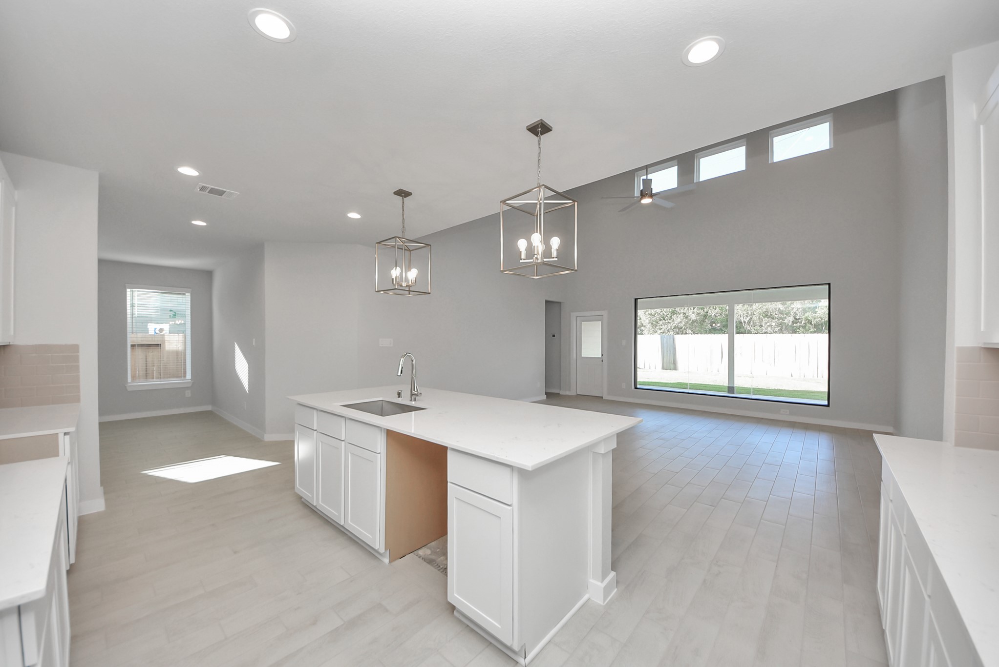 Step into a dream realized with this generously spacious kitchen! A massive granite island takes center stage, complemented by high ceilings and soft-close cabinets. The granite countertops, stainless steel appliances, sleek tile backsplash, and recessed lighting complete the elegant design.