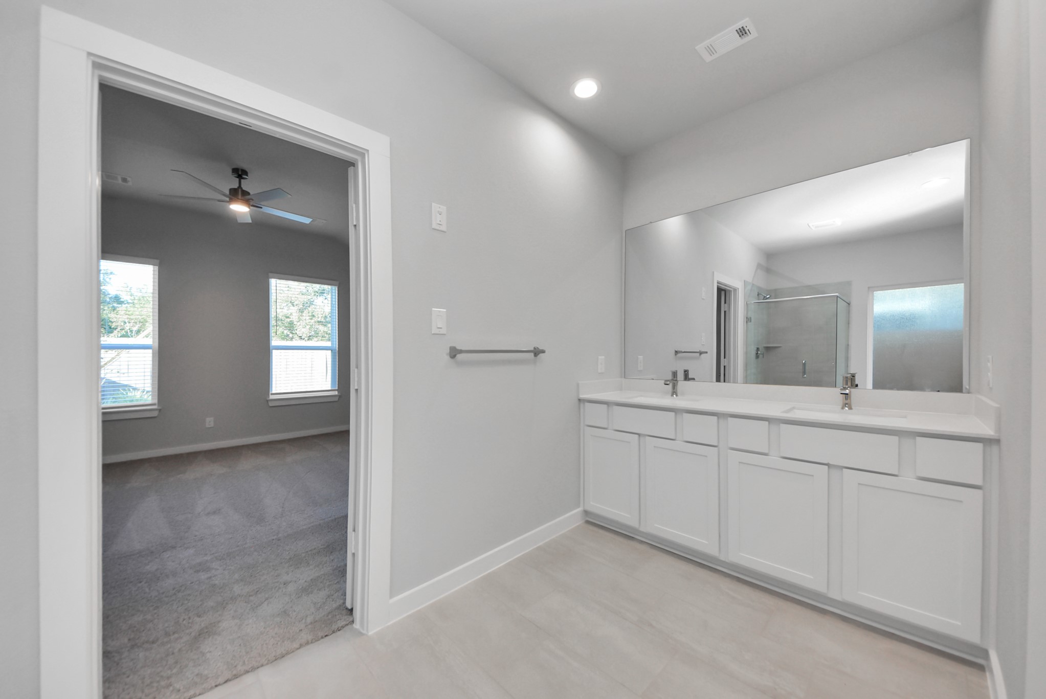 Escape to a spa-like oasis in this primary bathroom. Enjoy a walk-in shower with tile surround, a separate garden tub with custom detailing, and an elegant vanity featuring light countertops, modern hardware, and beautiful vanity lights. Experience luxury and relaxation in every detail.