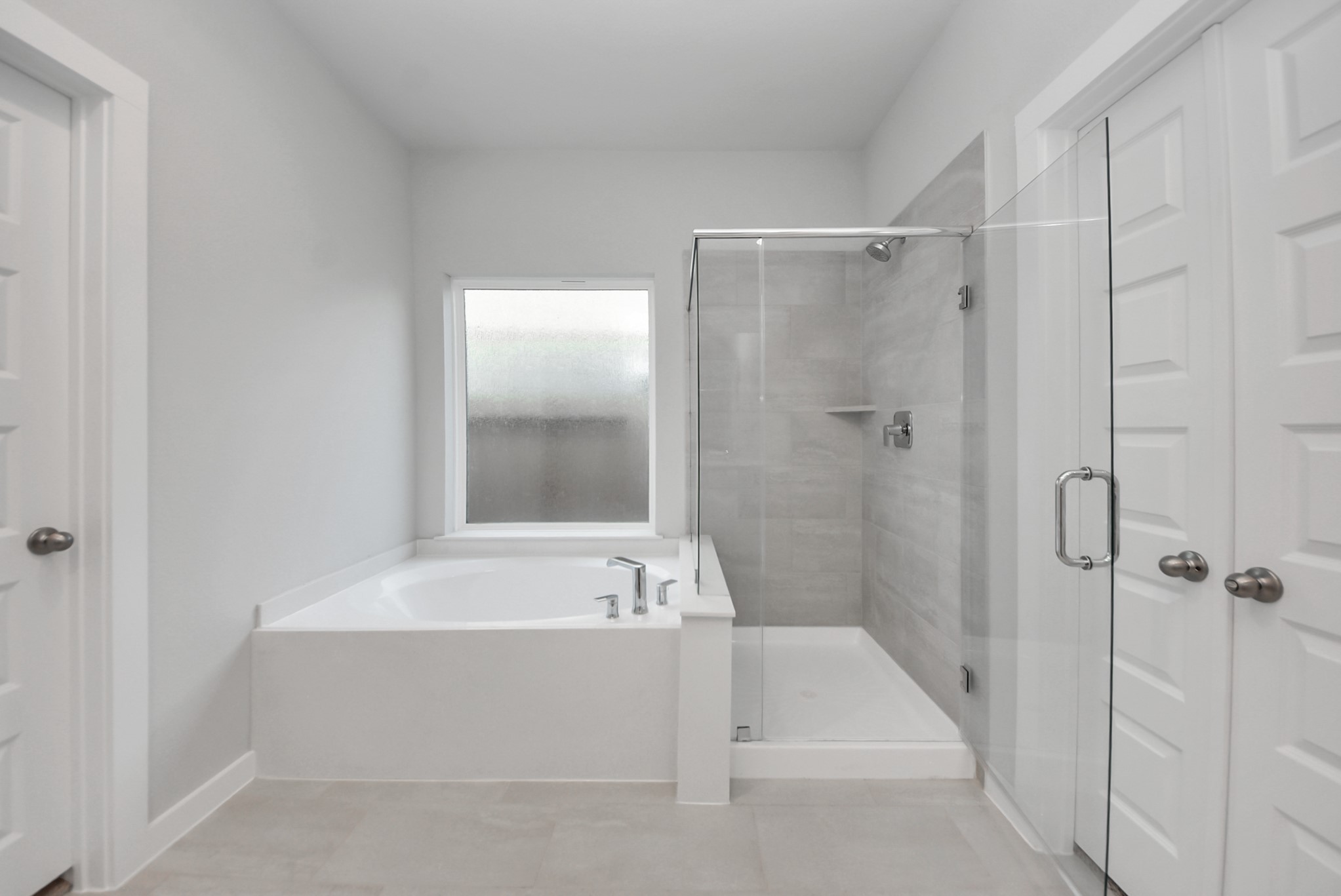 Indulge in a spa-like retreat within the confines of this primary bathroom. Delight in a spacious walk-in shower enveloped in stylish tile surround, unwind in a separate garden tub adorned with custom detailing.