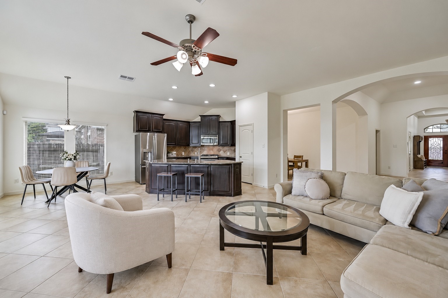 The spacious family room flows seamlessly into the kitchen & breakfast area, creating an open, inviting gathering space! Neutral tile flooring extends throughout, while recessed lighting, a ceiling fan & graceful arched openings complement the freshly painted interior. A wonderful layout with room to spread out!