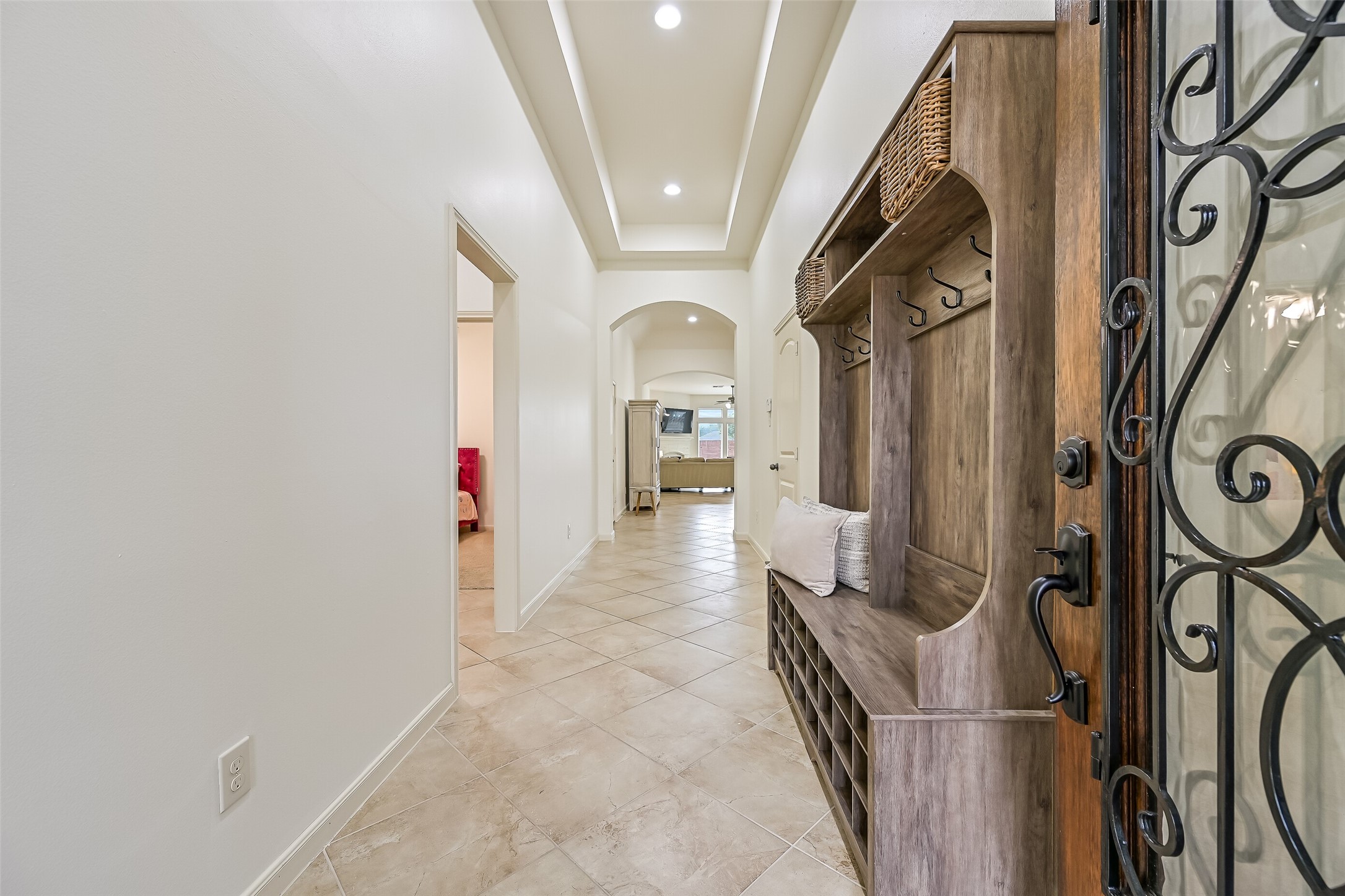 Step inside to a welcoming entry featuring a recessed tray ceiling with lighting, diagonally laid tile flooring & freshly painted neutral walls. Graceful arched openings draw your eye toward the spacious family room at the rear of the home, creating an inviting introduction to this single-story floor plan.
