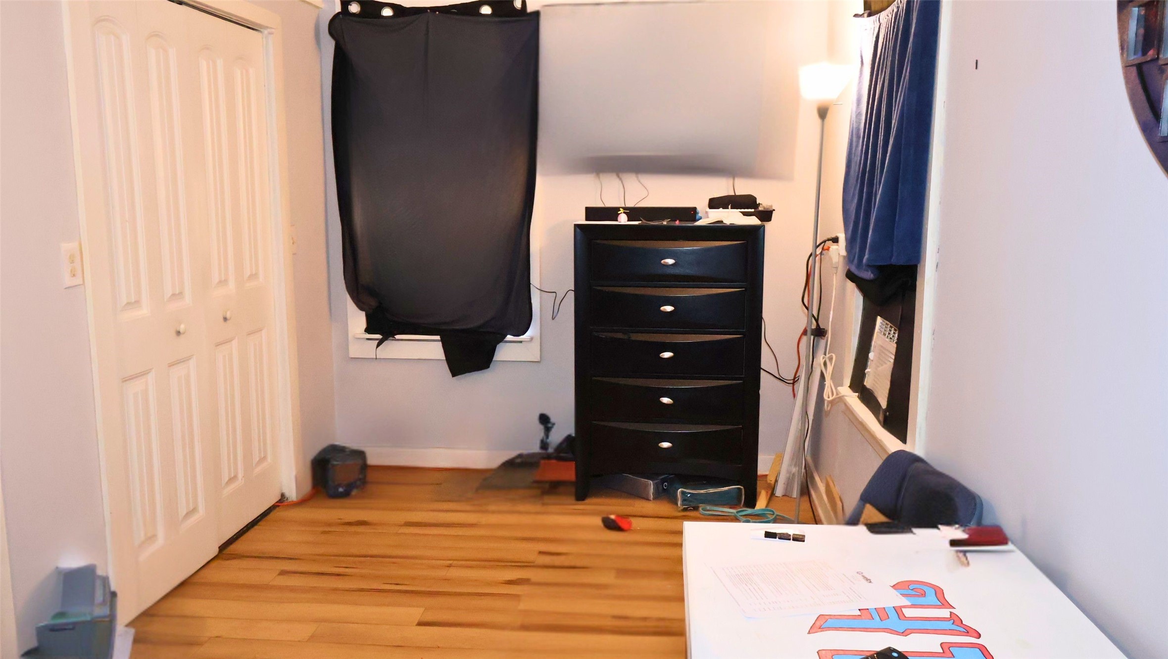 Cozy sitting room connected to the bedroom with hardwood flooring, featuring a closet with double doors.