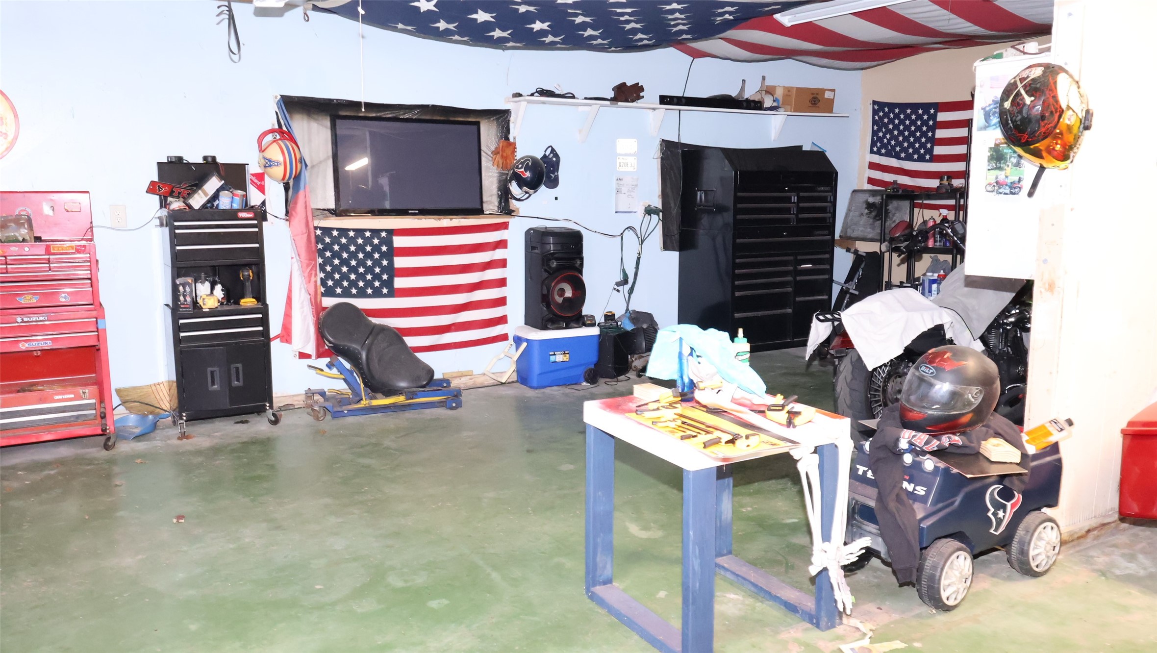 Spacious one-car garage with ample storage, tool chests, and a workbench, perfect for DIY enthusiasts.