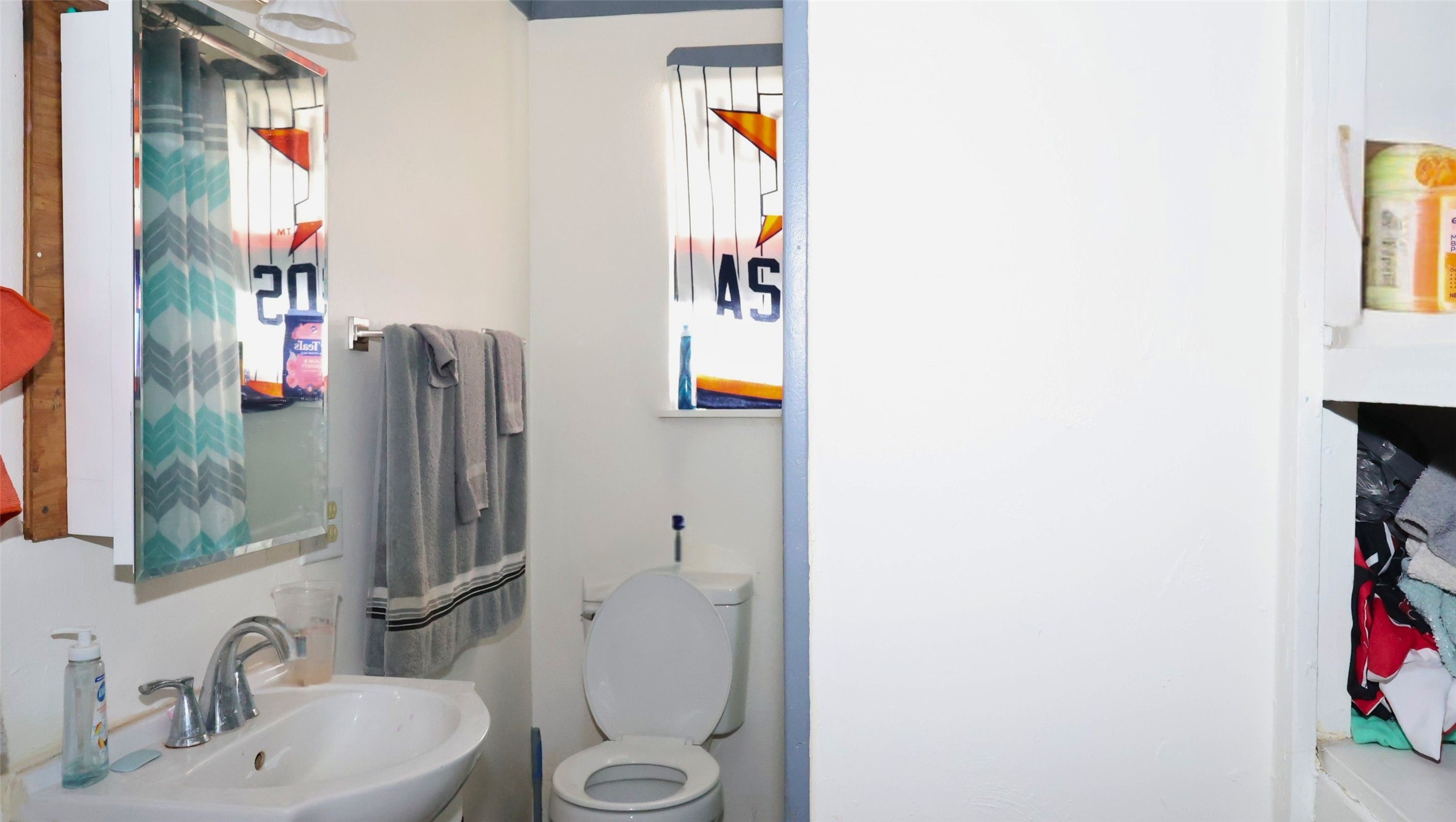 Cozy bathroom with a single vanity, modern fixtures, and ample natural light from a decorative window. Cozy bathroom with a single vanity, modern fixtures, and ample natural light from a decorative window.