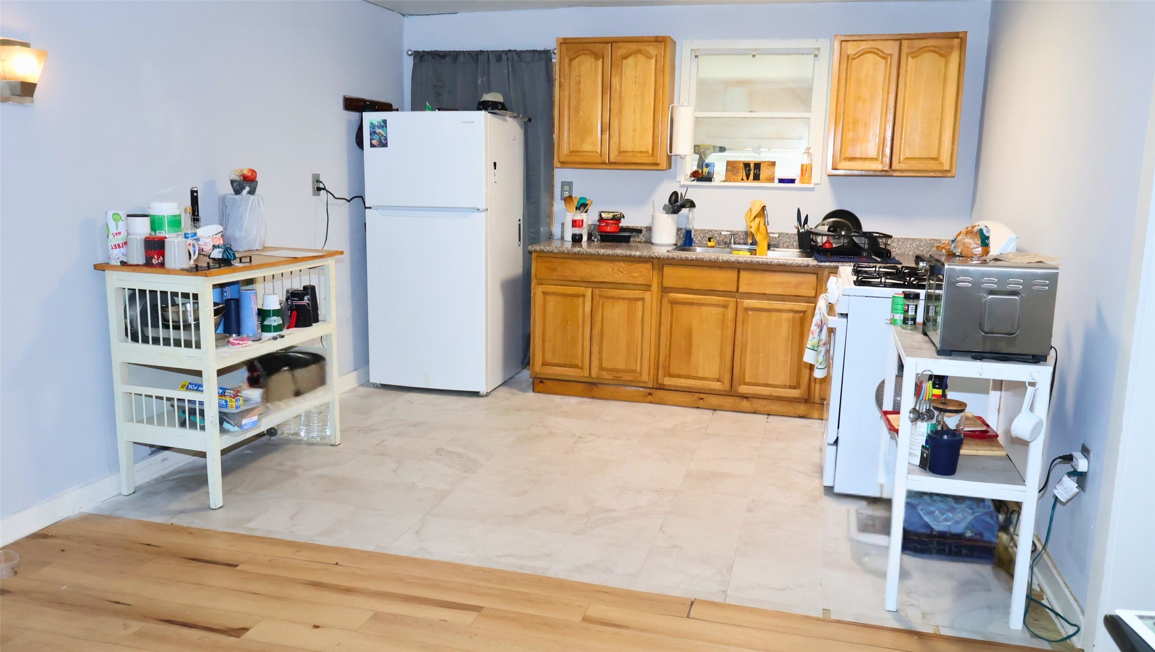 Cozy kitchen with wooden cabinets, ample counter space, and a practical layout featuring a fridge, stove, and microwave. Cozy kitchen with wooden cabinets, ample counter space, and a practical layout featuring a fridge, stove, and microwave.